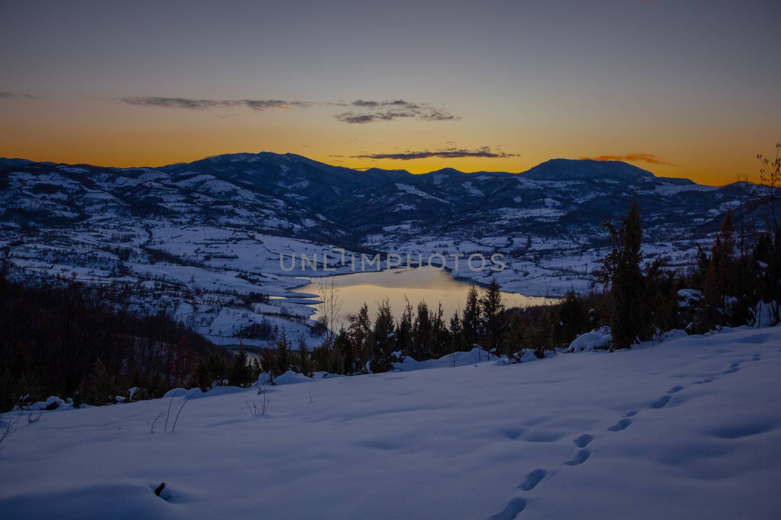 Colorful sunset evening at mountain lake Rovni in snow, beautiful nature winter scene in Serbia