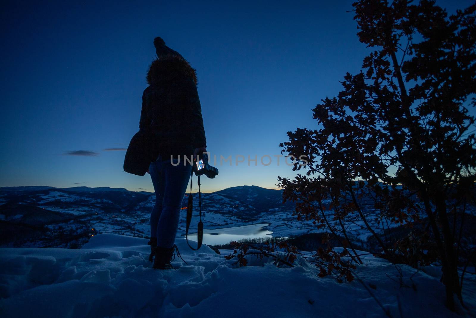 Photographers photographing winter lake mountain scene in sunset by adamr