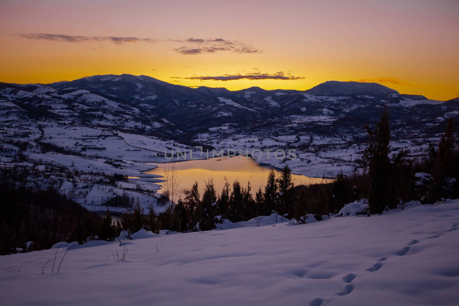 Colorful sunset evening at mountain lake Rovni in snow, beautiful nature winter scene in Serbia