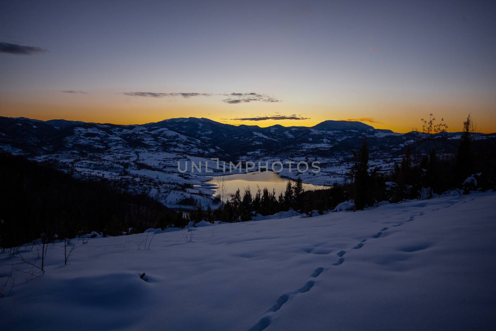 Colorful sunset evening at mountain lake Rovni in snow, beautiful nature winter scene in Serbia