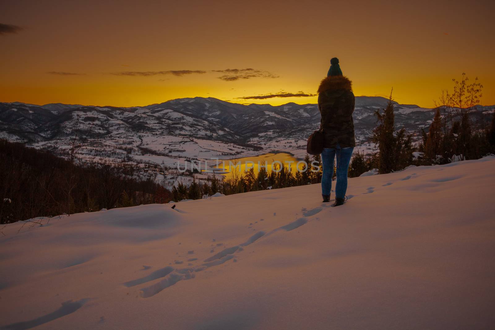 Photographers photographing winter lake mountain scene in sunset, alone in wilderness. Rovni, Valjevo, Serbia