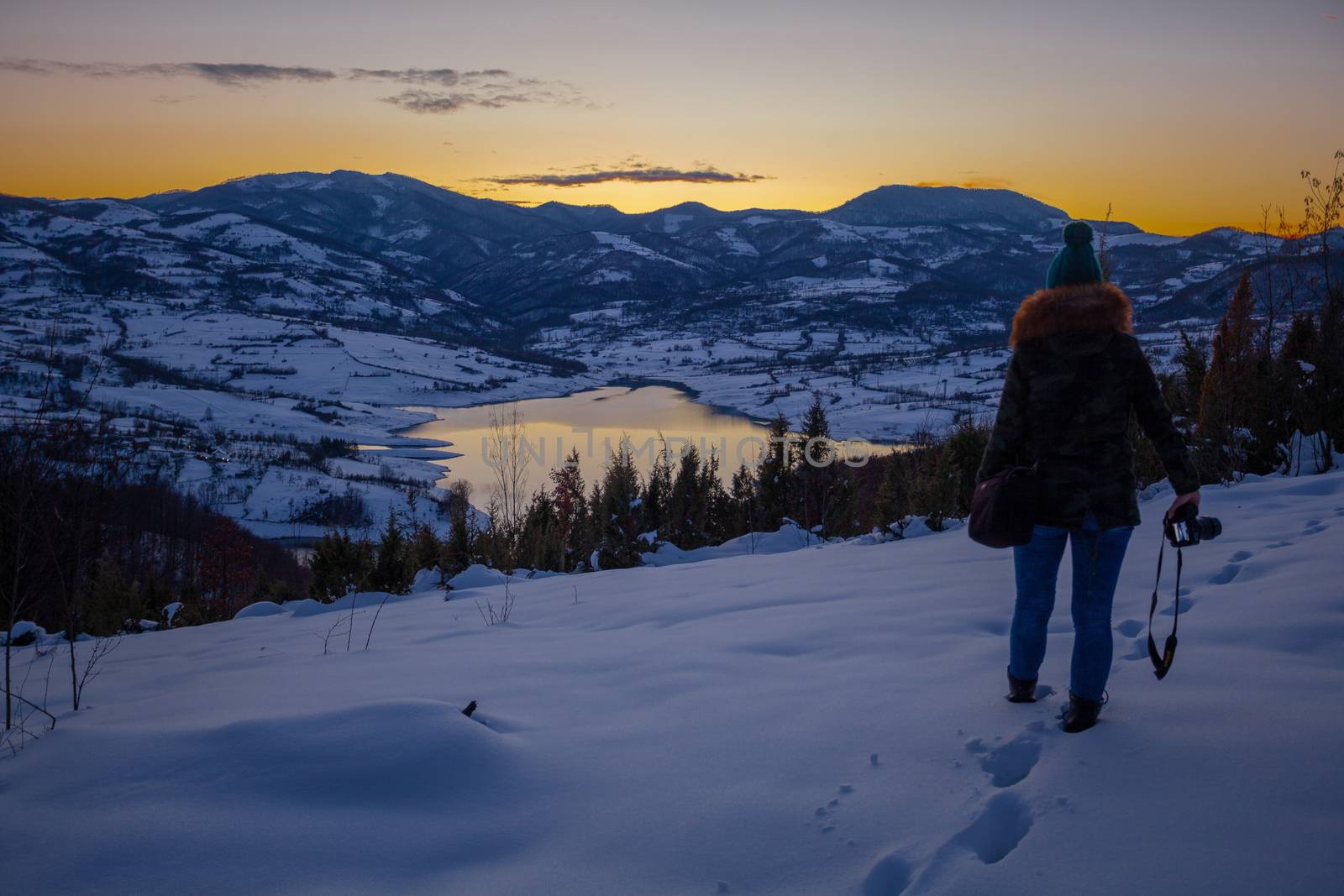 Photographers photographing winter lake mountain scene in sunset by adamr