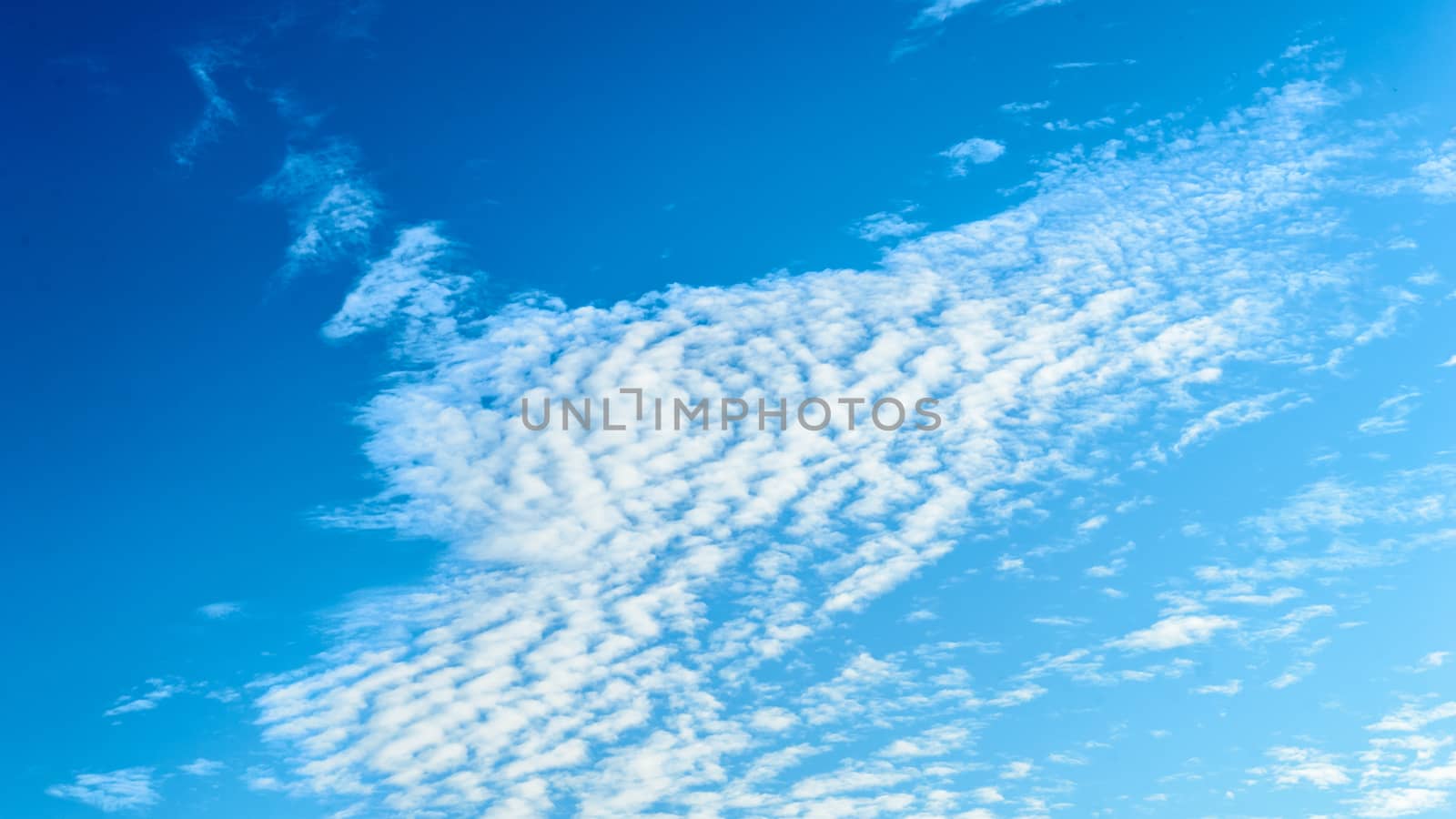 Cloudy sky background. Blue sky clouds background. Aesthetic blue sky wallpaper. Beautiful Cloudscape photography in summer. Tranquility theme. Copy space room for text in the middle of the Image. by sudiptabhowmick
