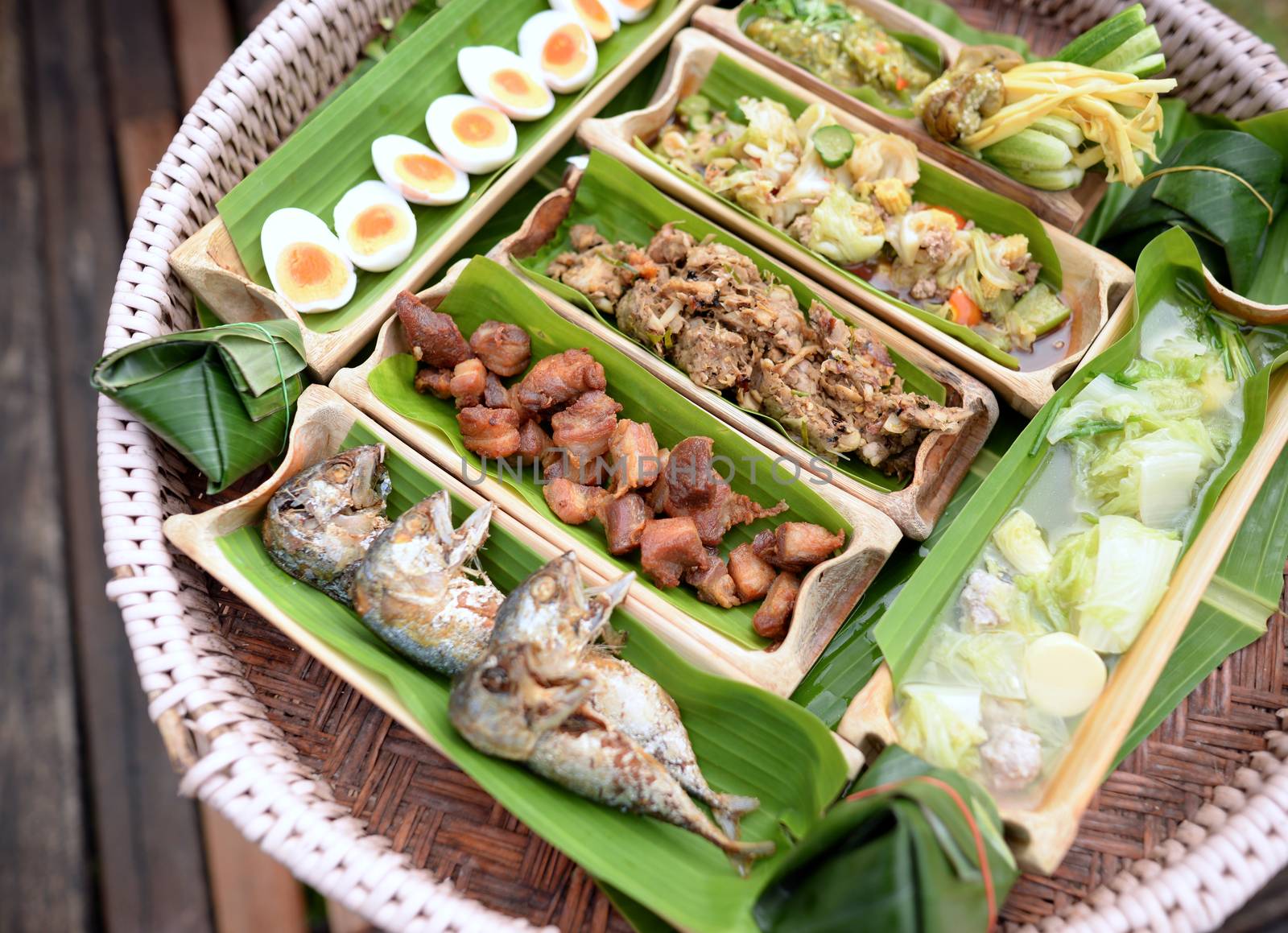 Fried mackerel, fried pork, boiled egg, clear soup, chili paste, boiled vegetables, stir-fried vegetables in a bamboo tube, cut in half, Secondary with banana leaf