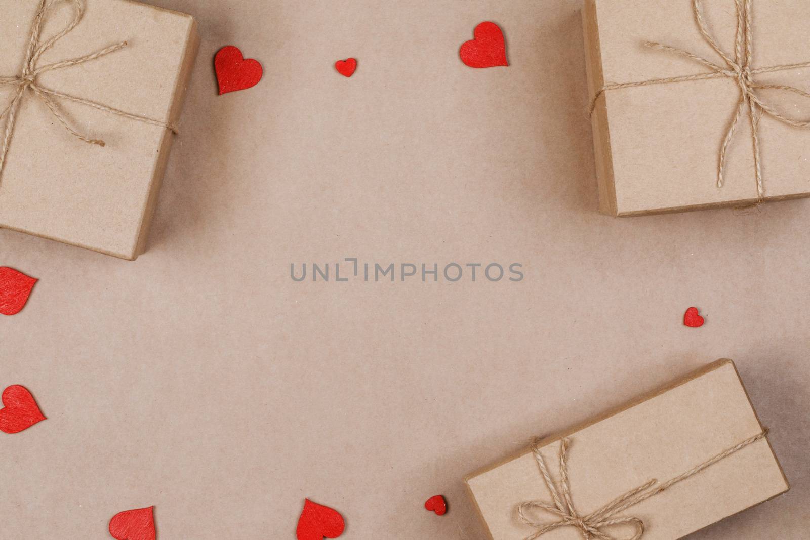 Boxes with gifts wrapped in brown craft paper and red paper hearts Valentines day concept