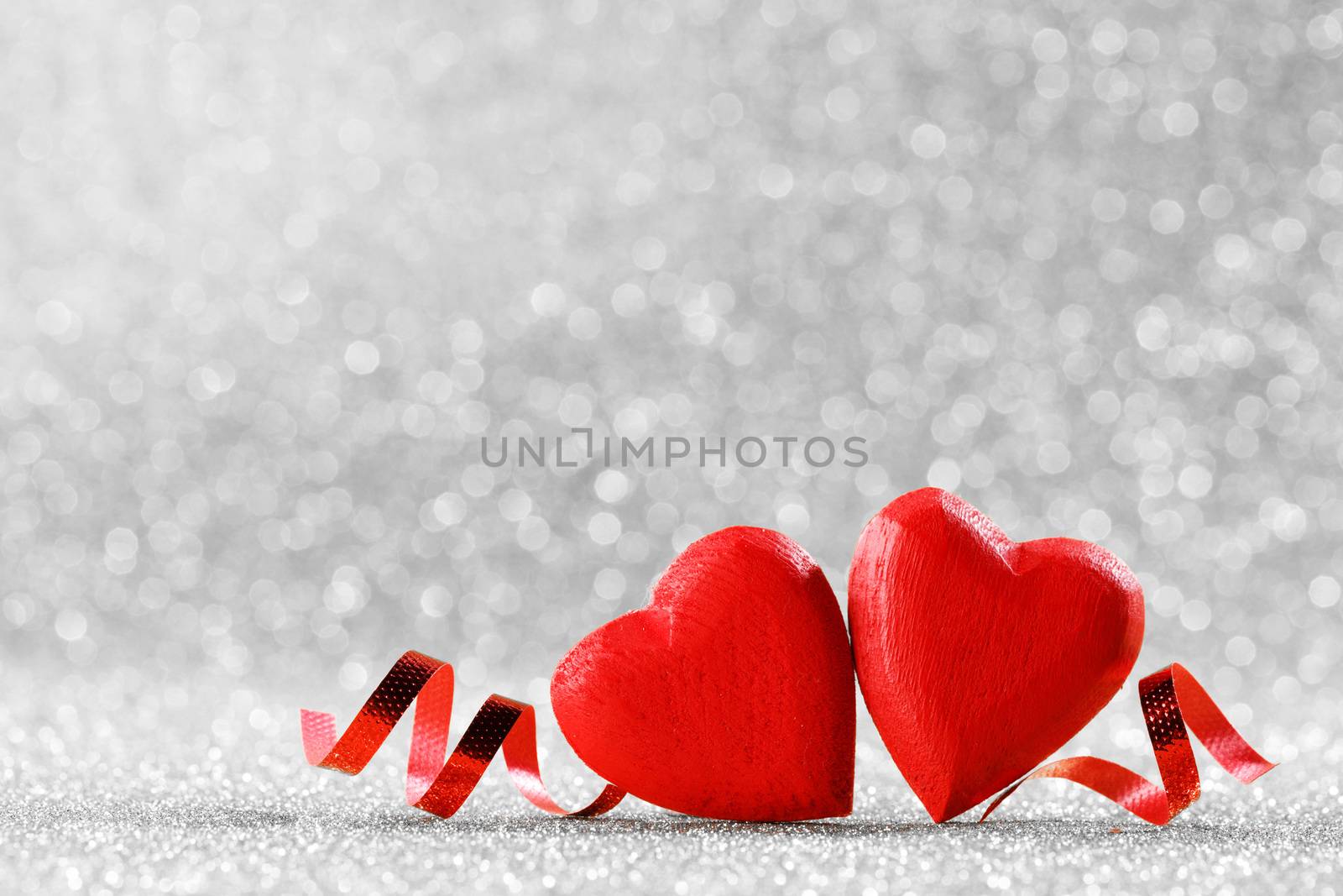 Two red wooden hearts symbol of love on background with beautiful bokeh, Saint Valentine Day celebration, copy space for text