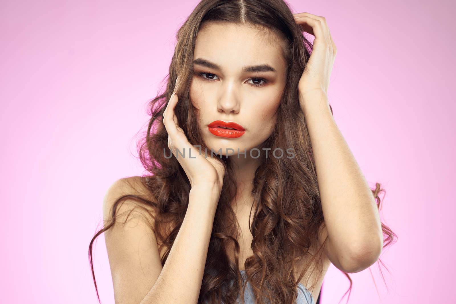 Woman with hairstyle and red lips naked shoulders bright makeup attractive look. High quality photo