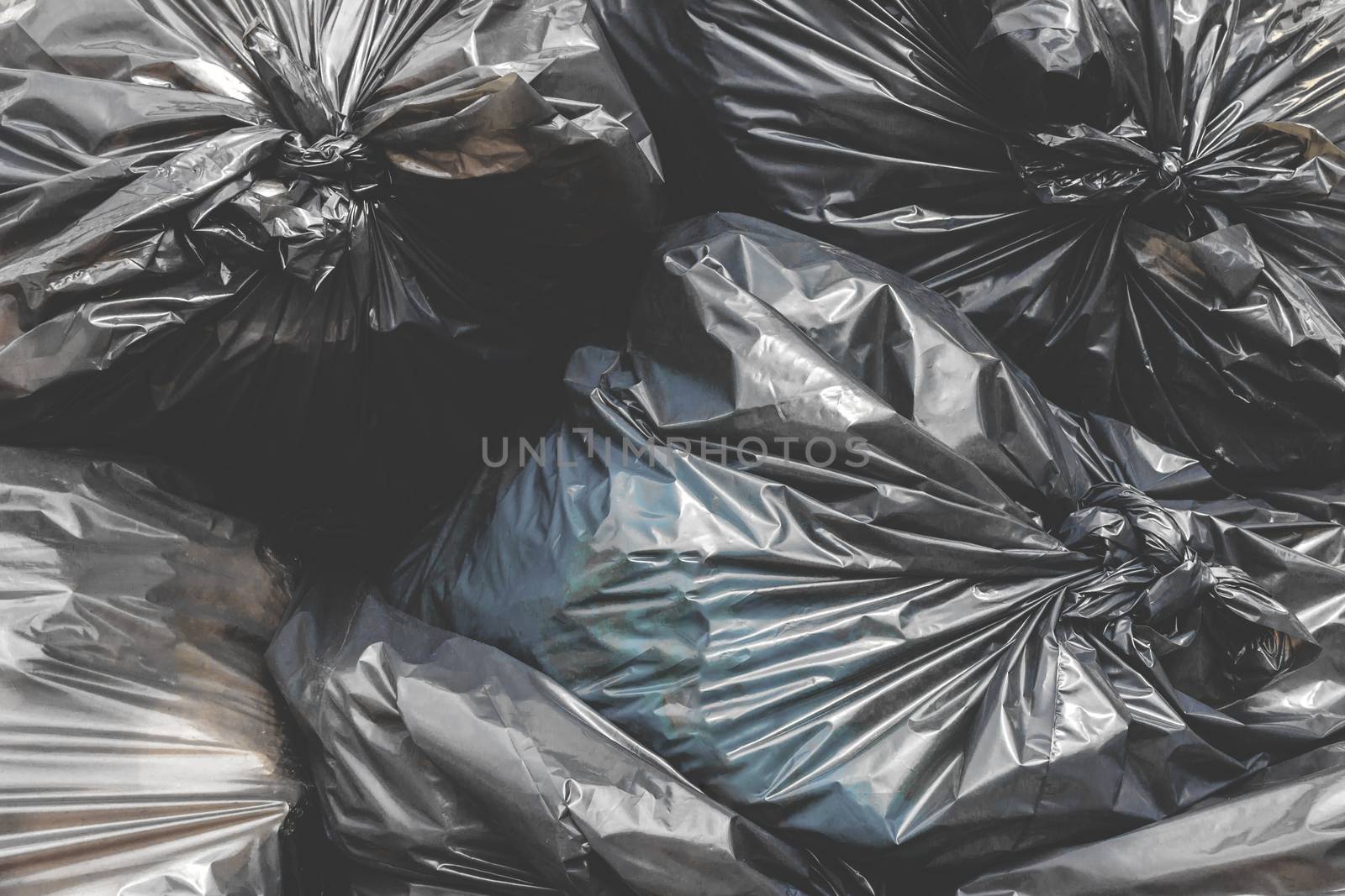 Garbage pile black plastic bags and trash bag waste pollution. Stack of black garbage bags.Black plastic bags for packaging waste.