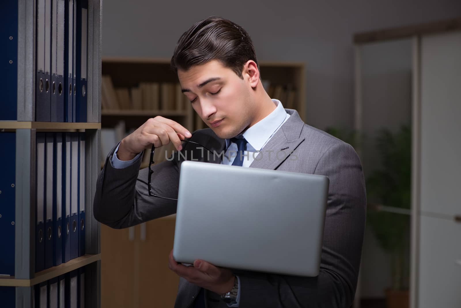 Businessman almost falling asleep working late hours in the office