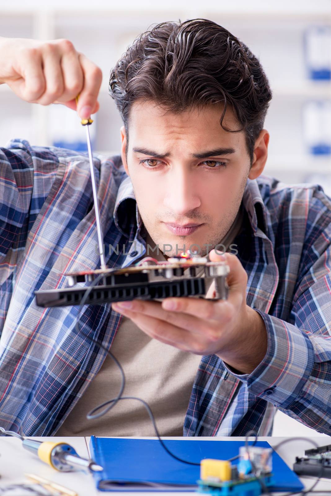 Professional repairman repairing computer in workshop