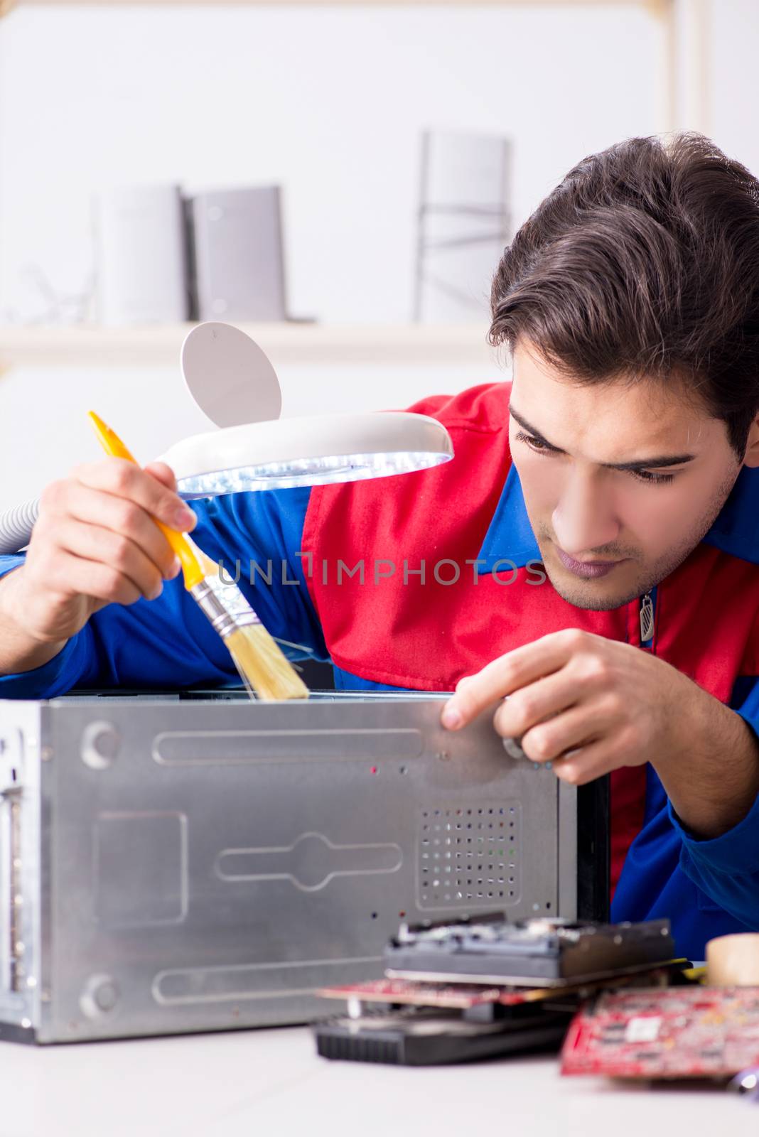 Professional repairman repairing computer in workshop