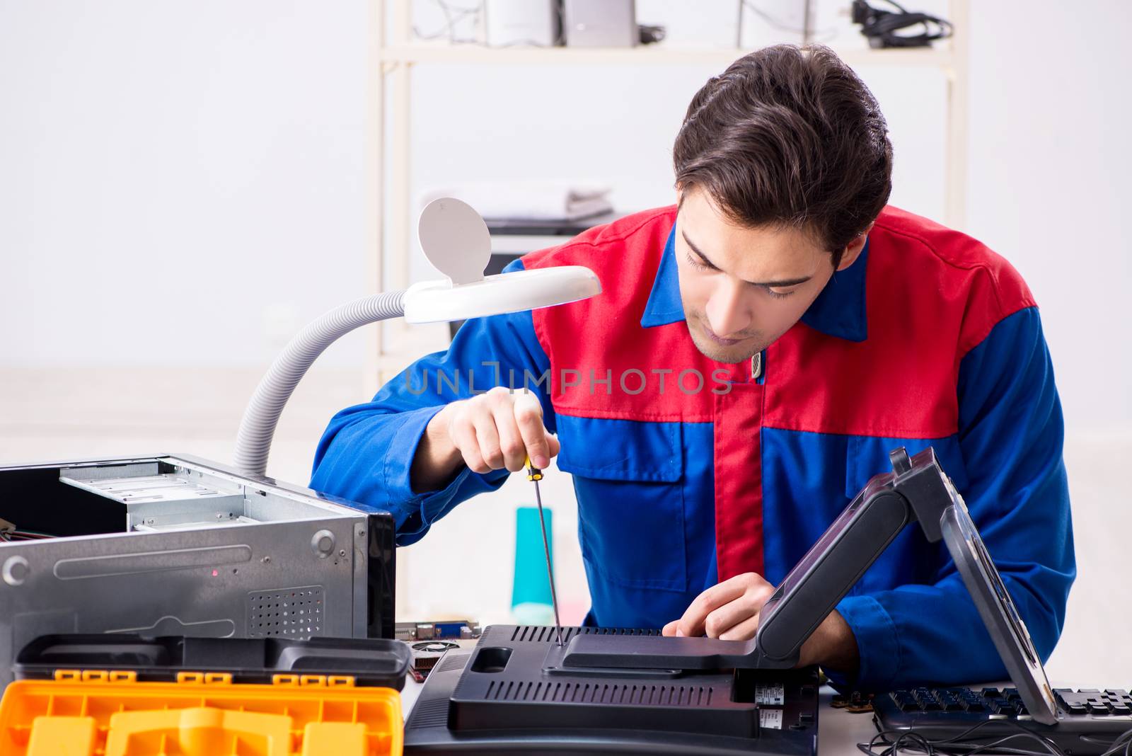 Professional repairman repairing computer in workshop