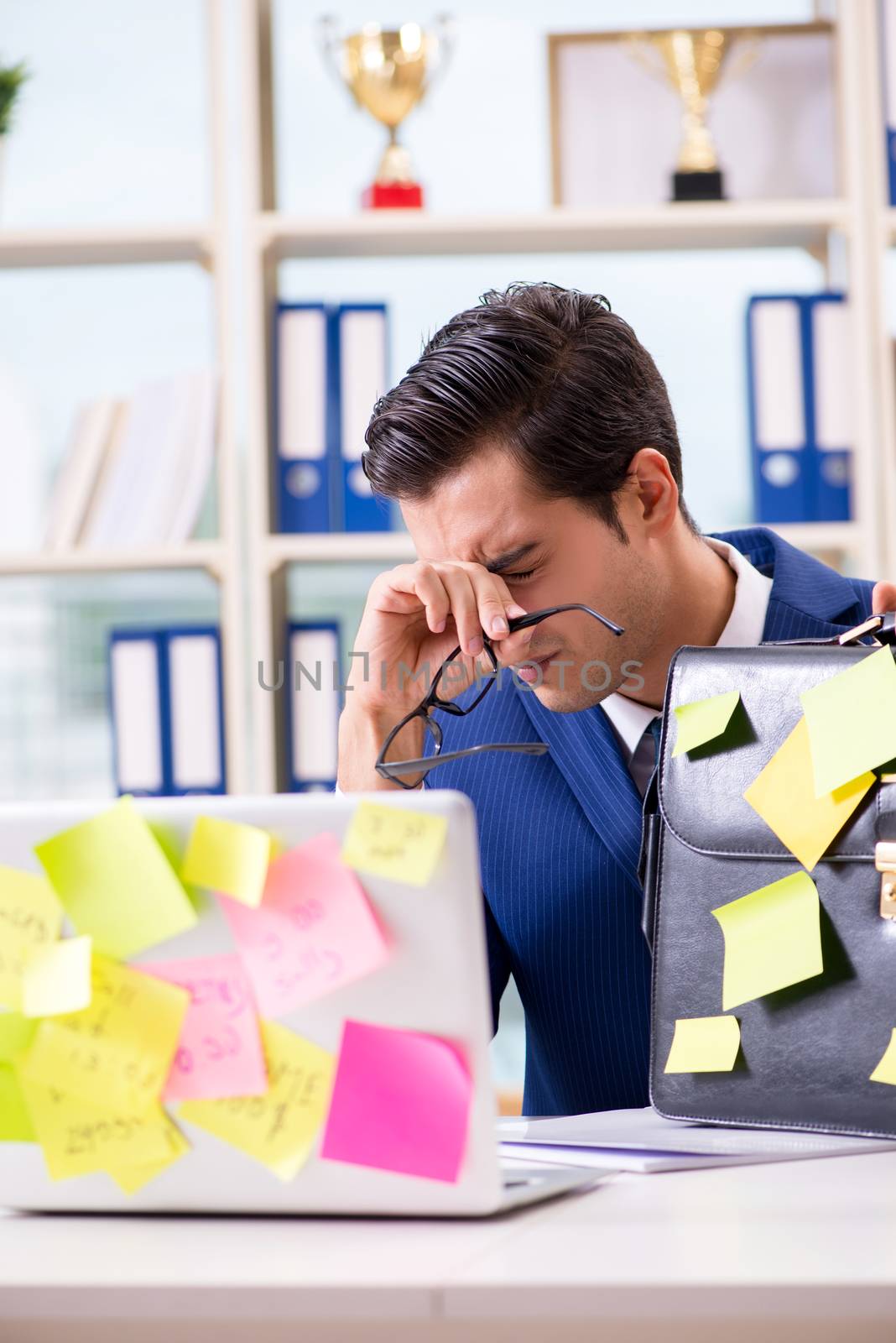 Businessman with reminder notes in multitasking concept