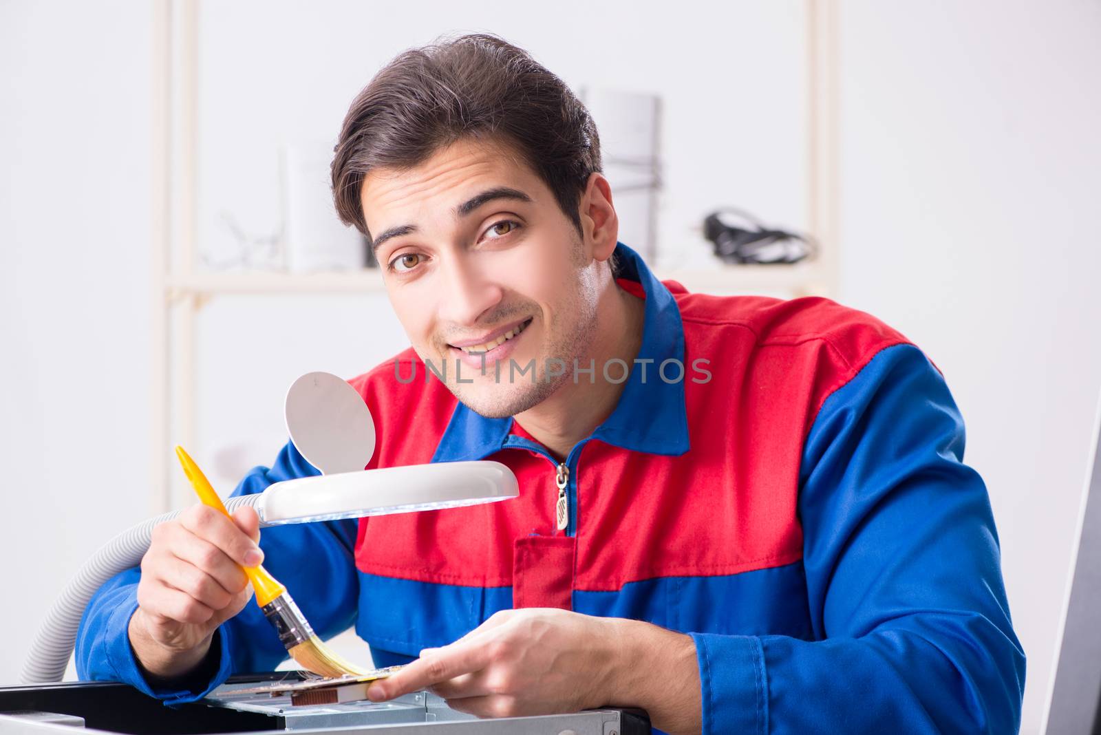 Professional repairman repairing computer in workshop