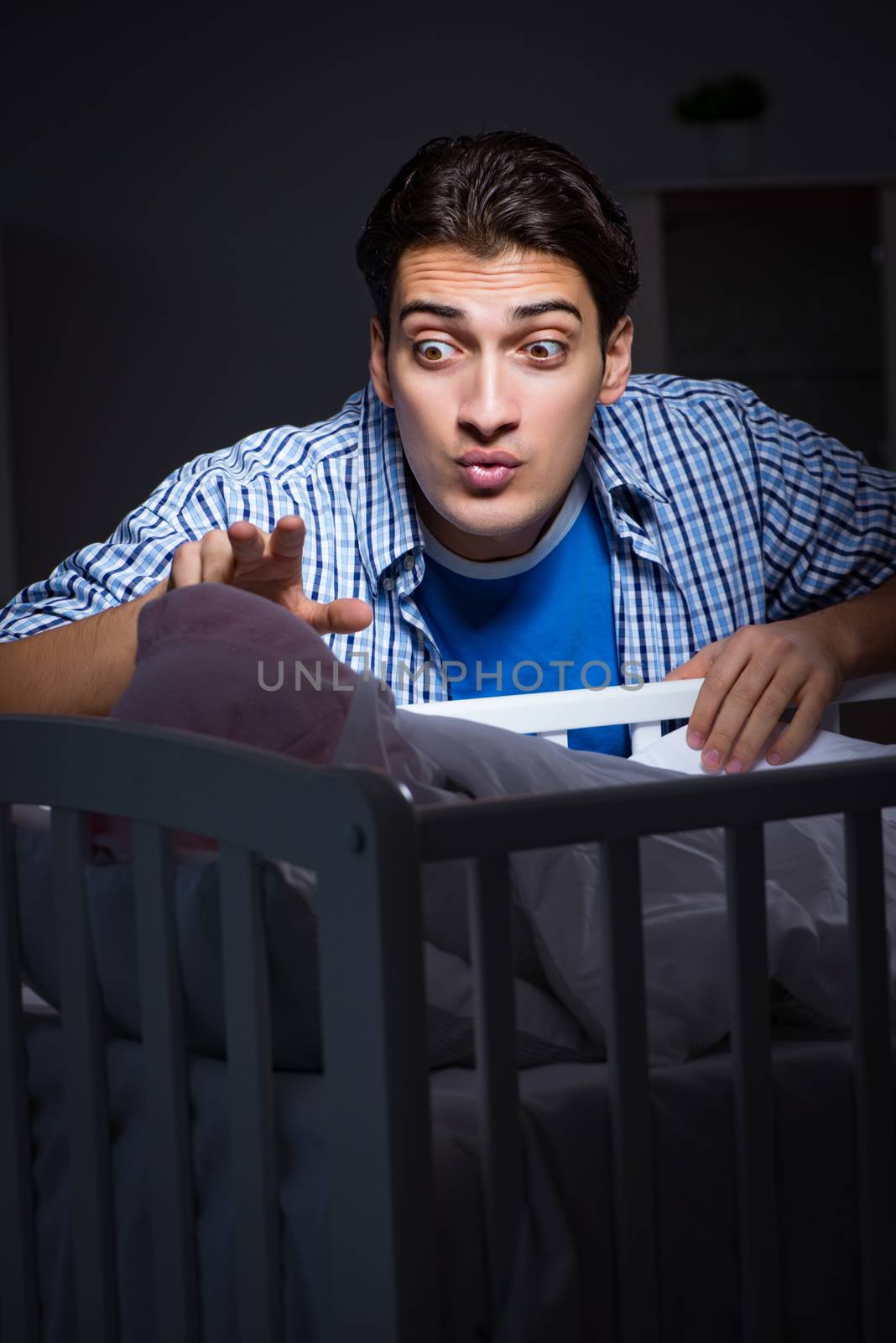 Happy dad looking after newborn baby at night