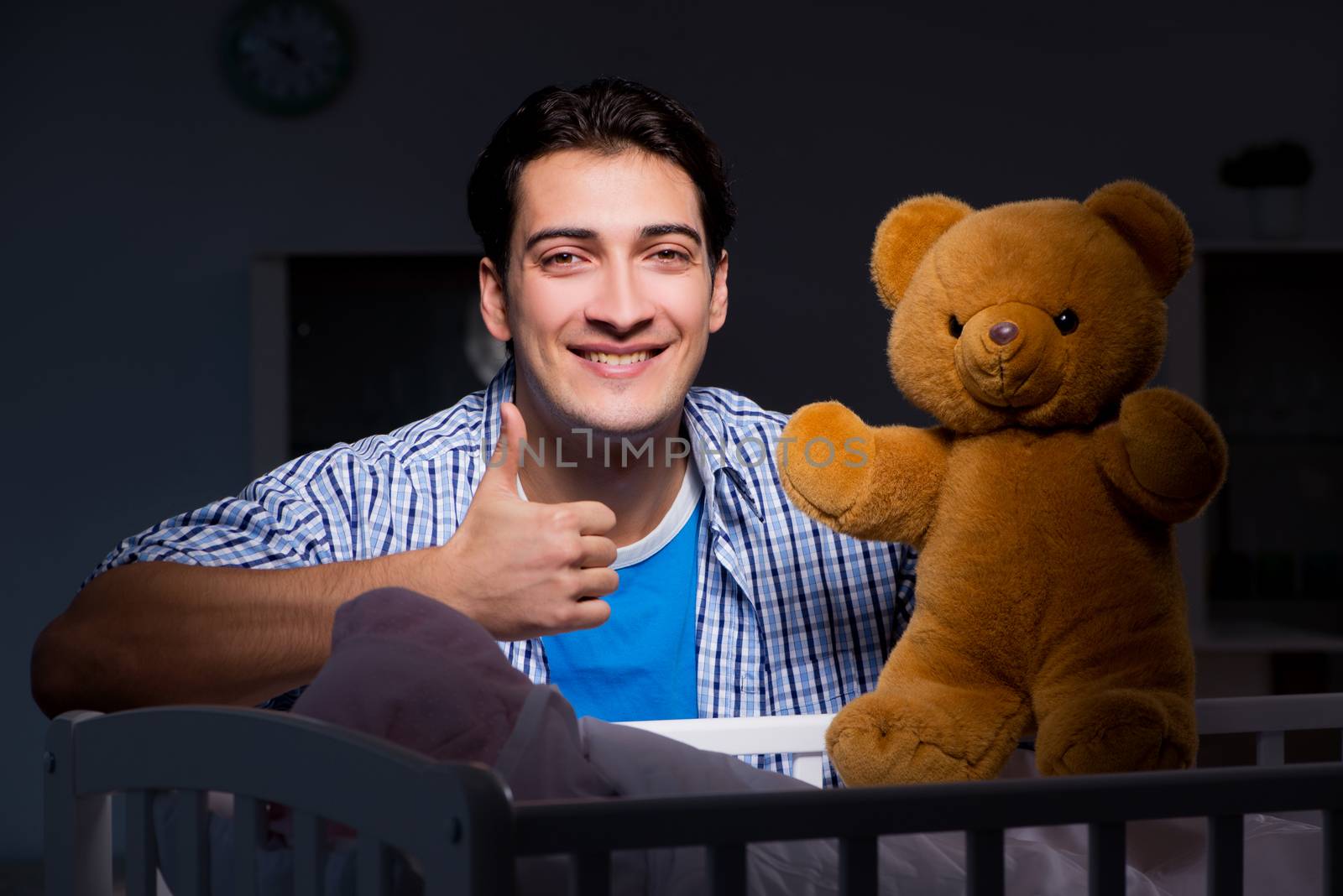 Happy dad looking after newborn baby at night