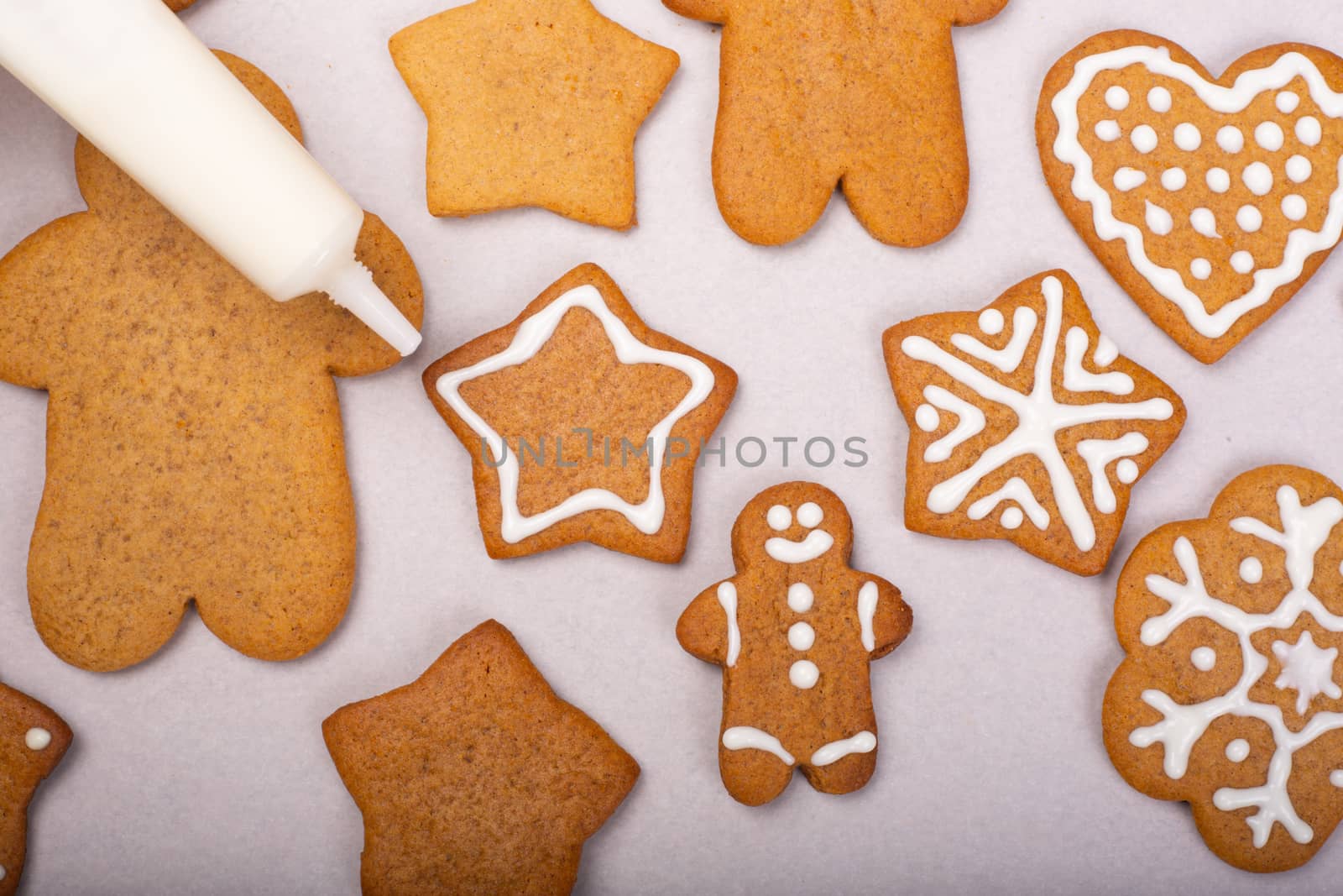 Close up of decorating the gingerbread cookies with white glaze, Merry Christmas concept