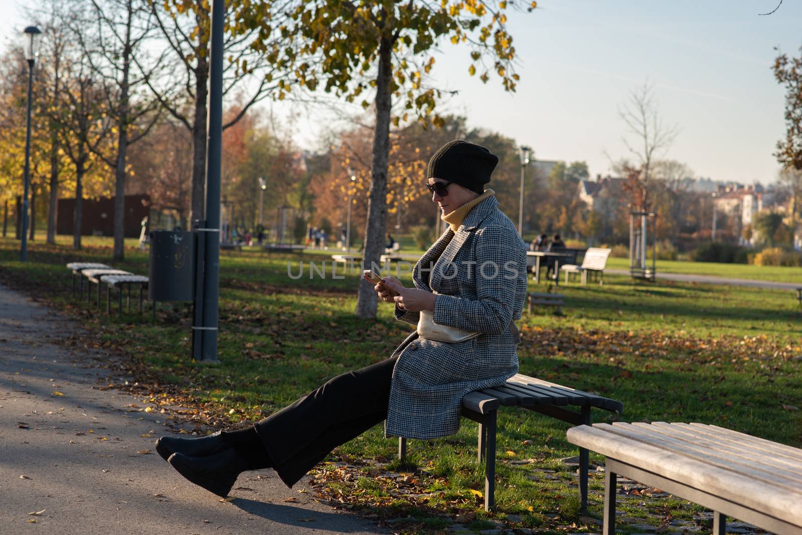 1/14/2020. Park Stromovka. Prague czech Republic. A woman is checking his phone in the park on a Sunday winter day. by gonzalobell
