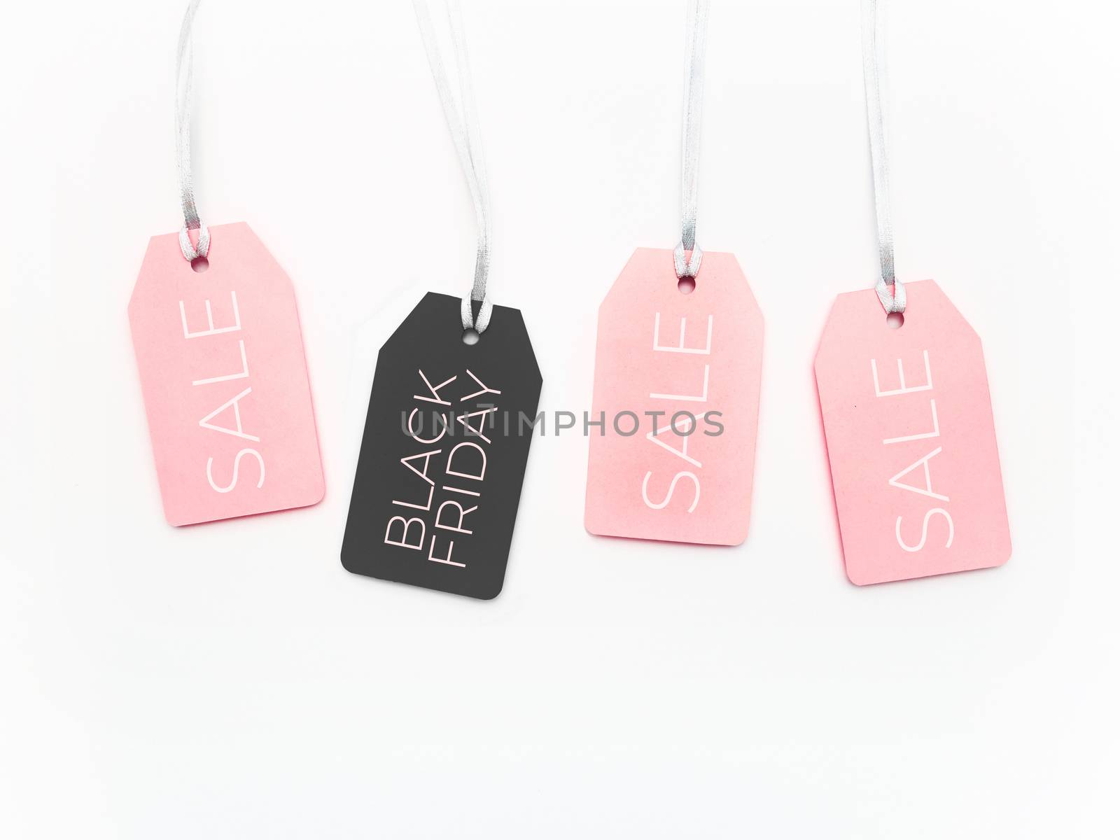 Pink and black tags on white background. Glamorous labels on silver threads. Black Friday sale and shopping. Top view, flat lay.