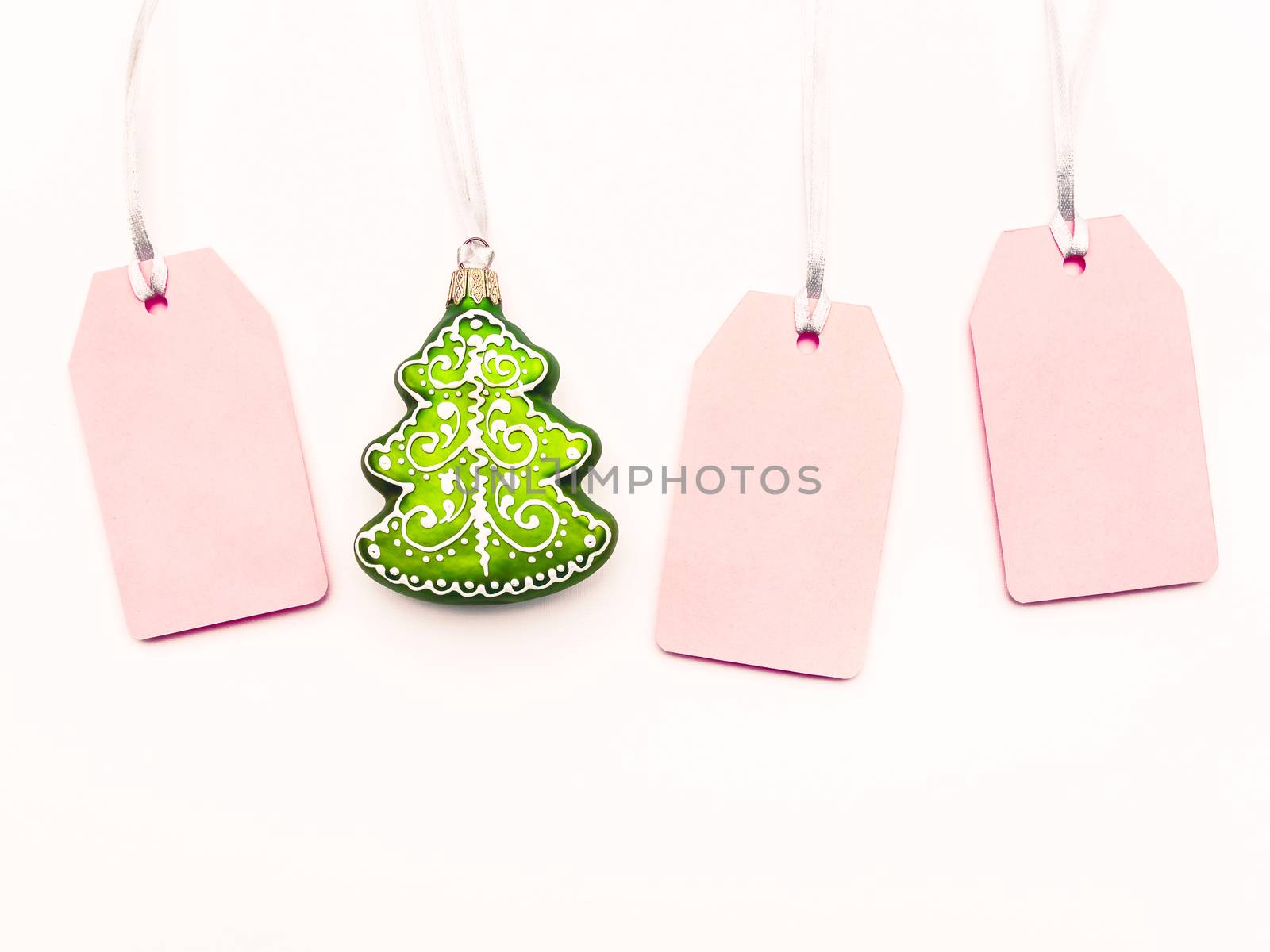 Three pink clear tags and decorative Chrsitmas tree on white bac by aksenovko