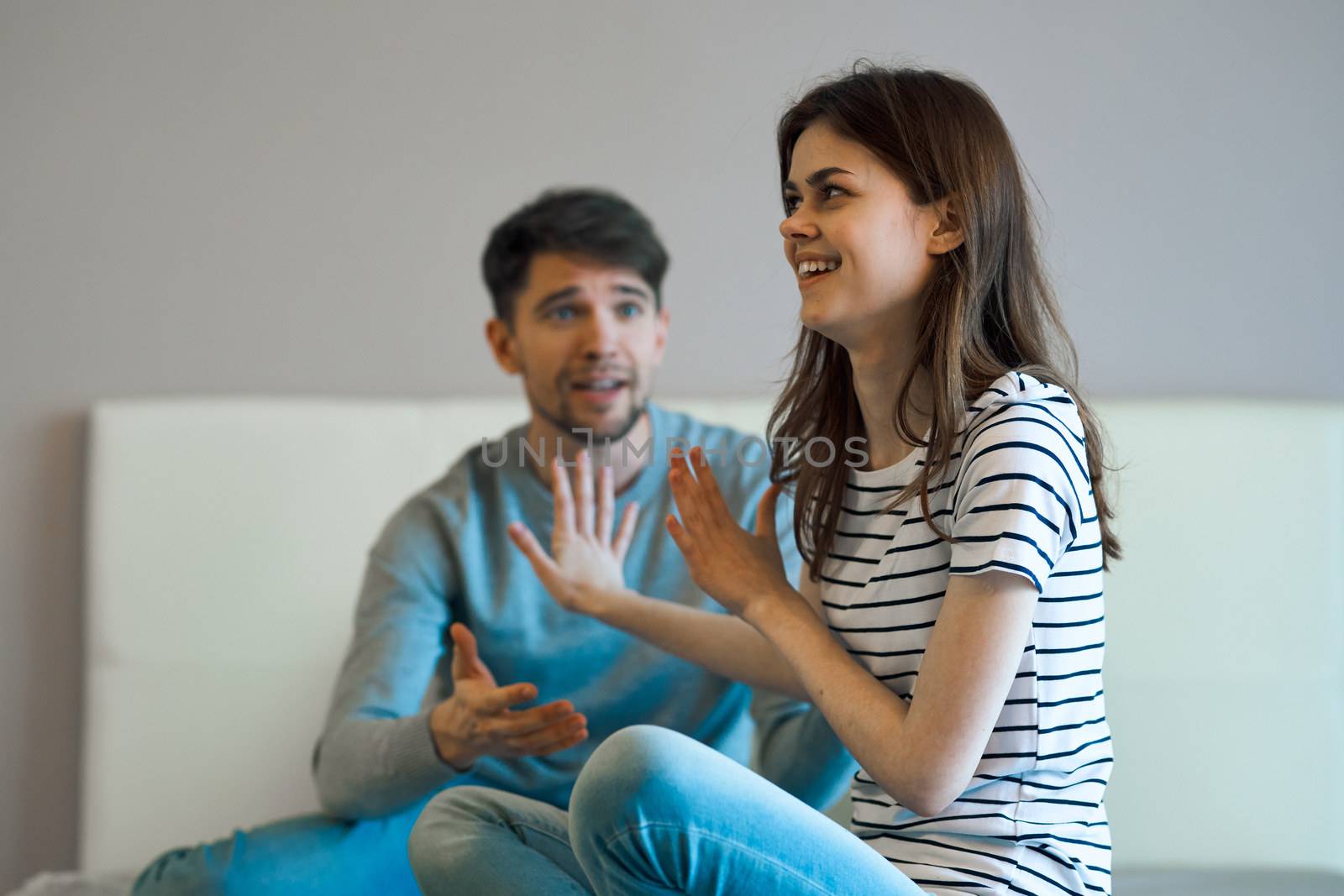 Cheerful woman and surprised Man on the couch chatting cropped view