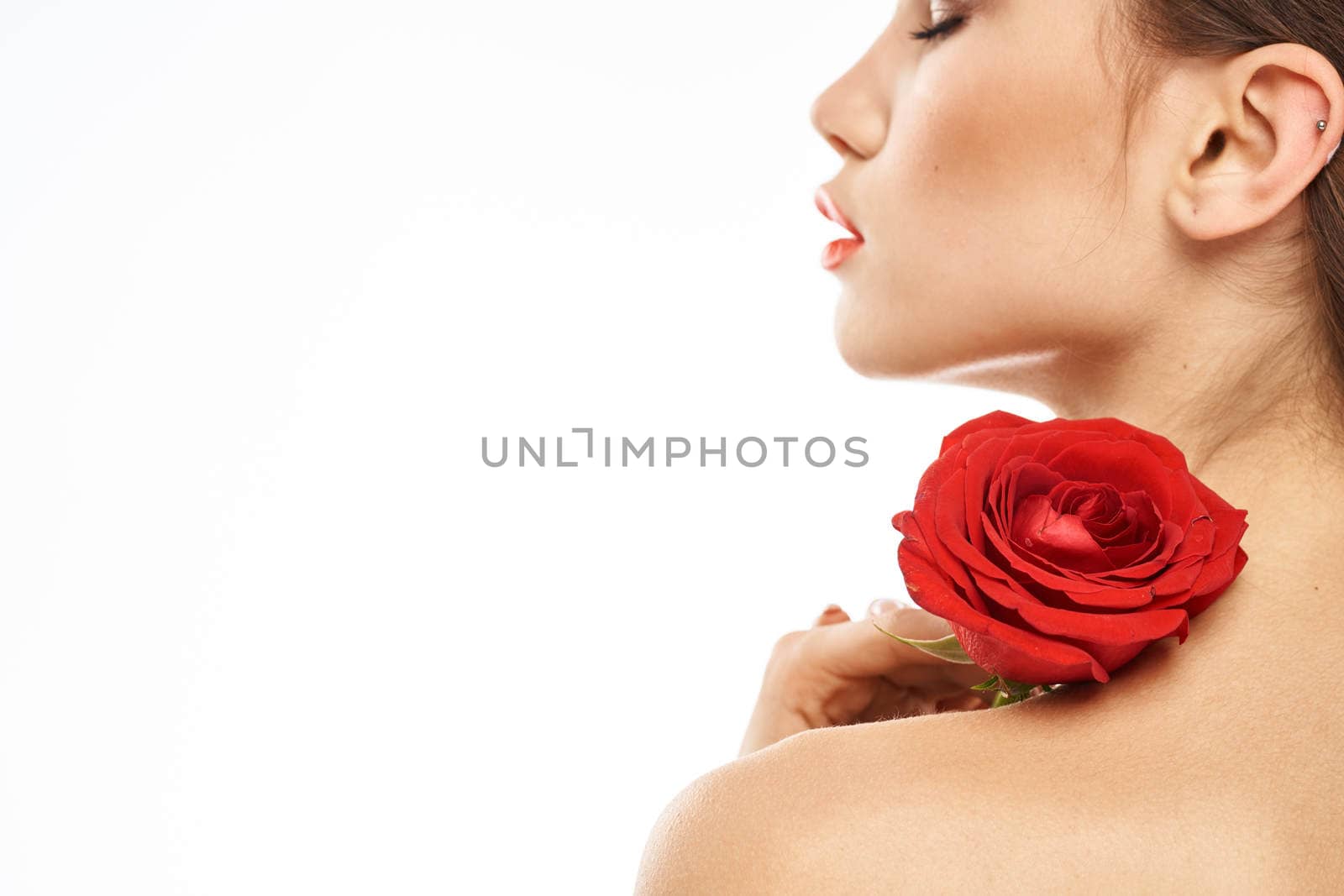 Portrait of woman with red rose naked shoulders Make-up on brunette face. High quality photo