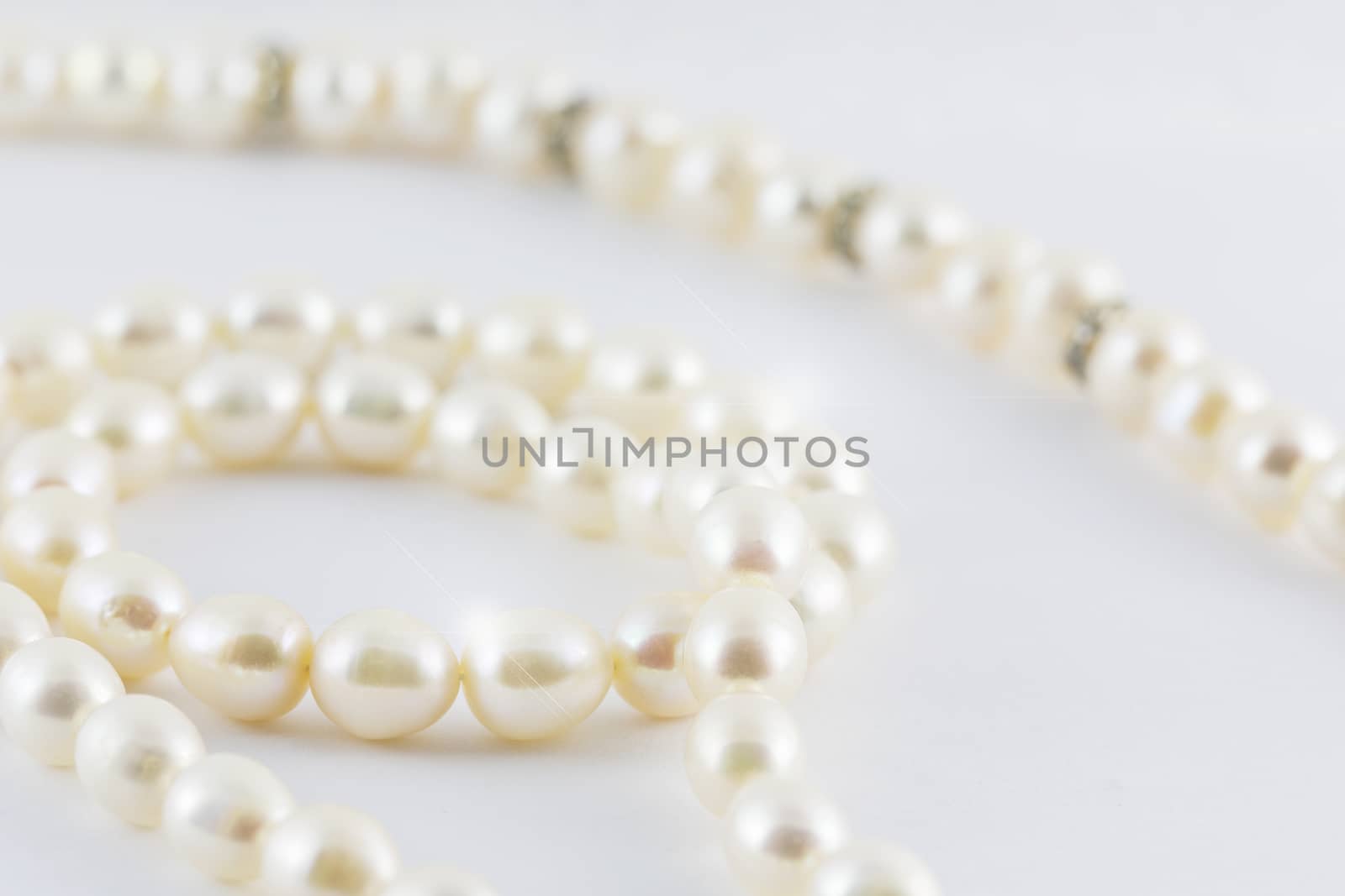 Beautiful creamy pearls necklace curve isolated on white backgro by jayzynism