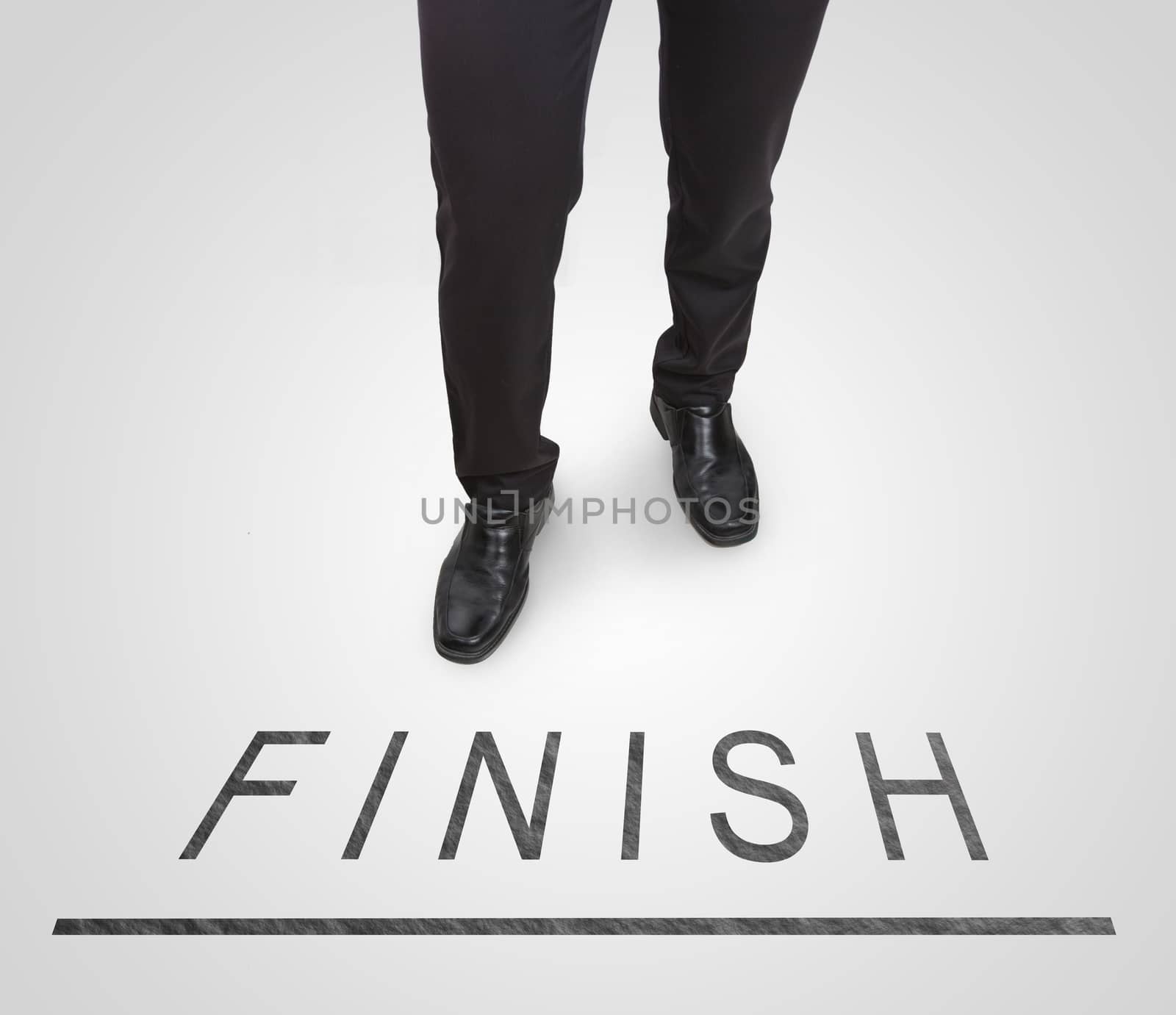 Businessman standing wearing court shoes on finish line. by jayzynism