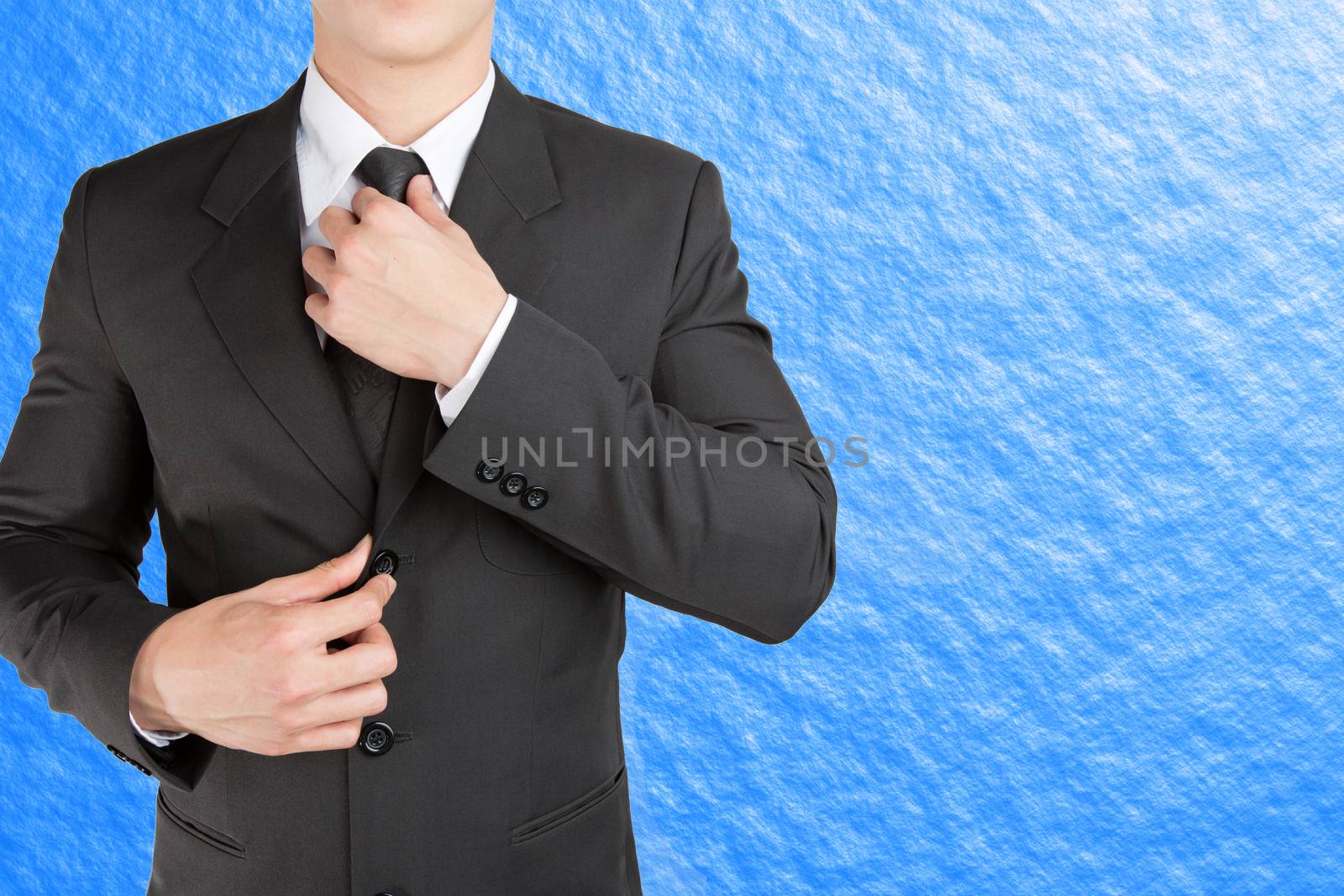 Well dressed businessman looklike smart adjusting  his neck tie  by jayzynism