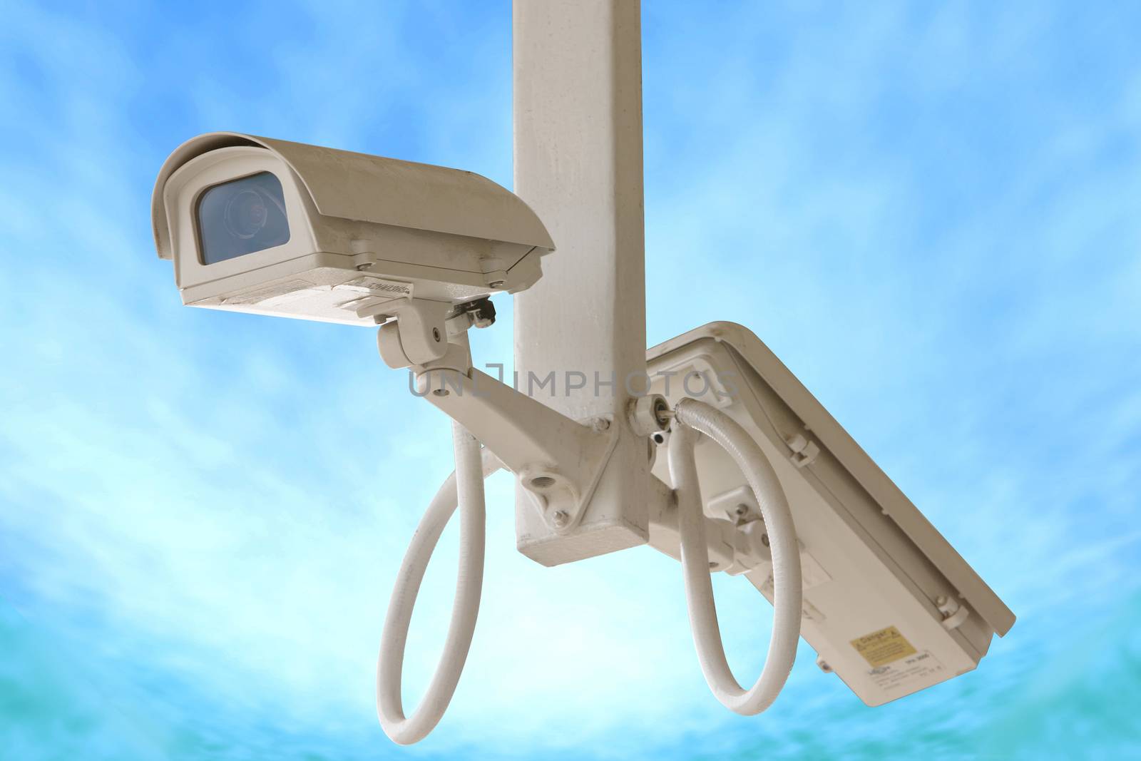 Security twin camera isolated on blue sky background.