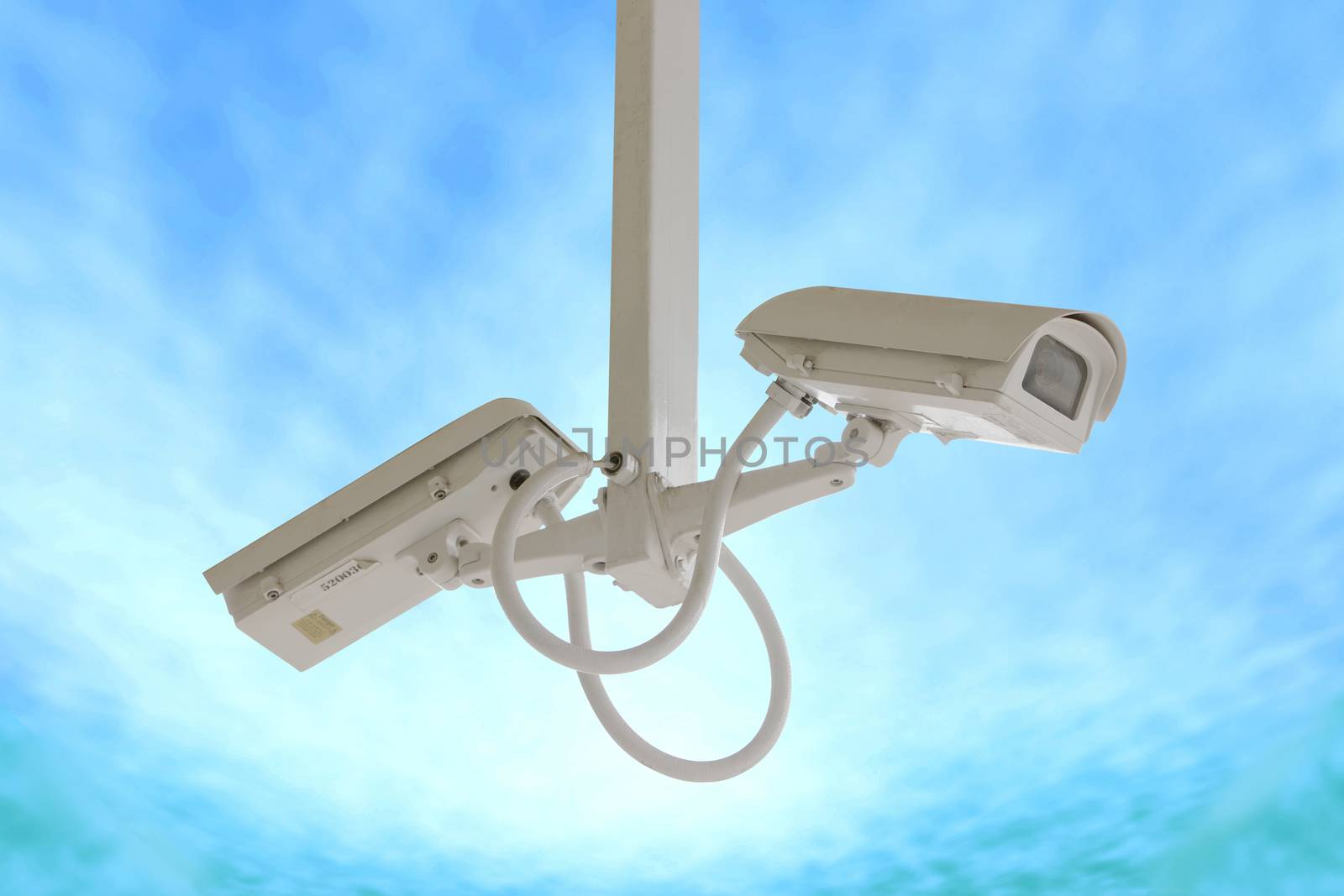 Security twin camera isolated on blue sky background.