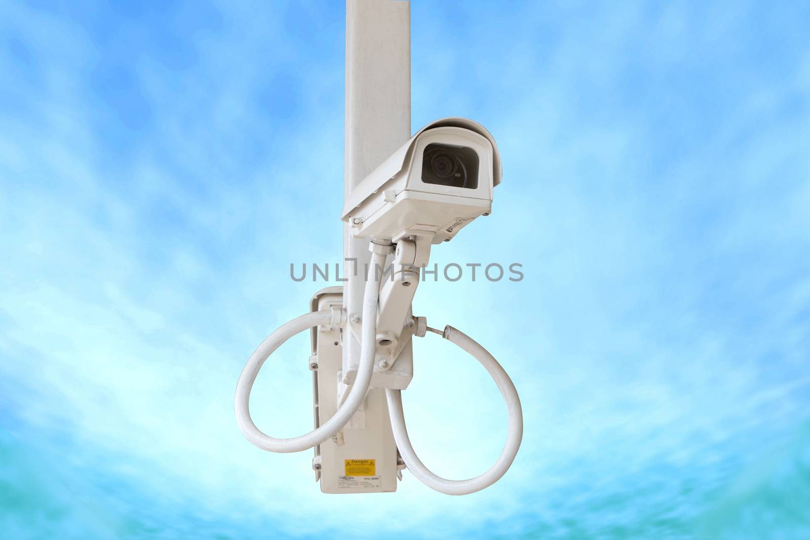 Security camera isolated on blue sky background.