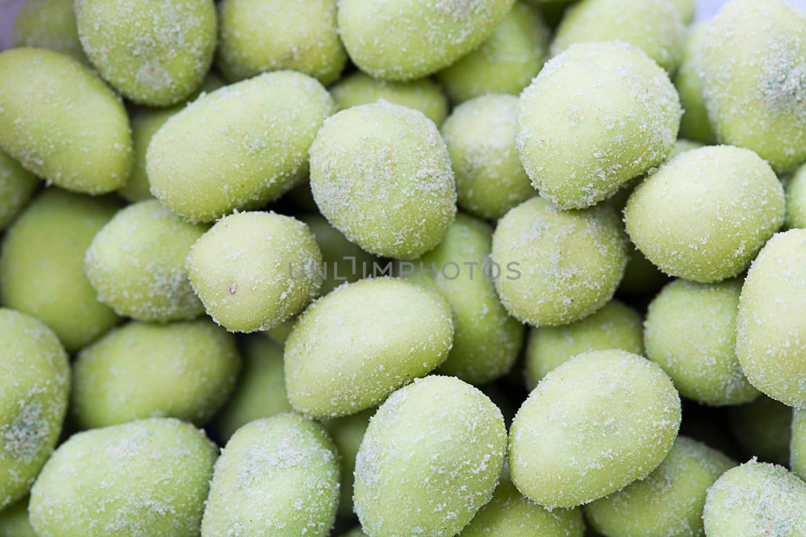 Closeup Wasabi coated peanuts. by jayzynism