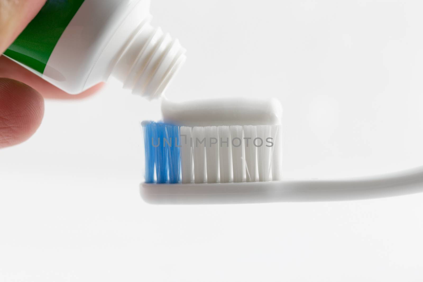 Hand press Toothpaste on tooth brush.