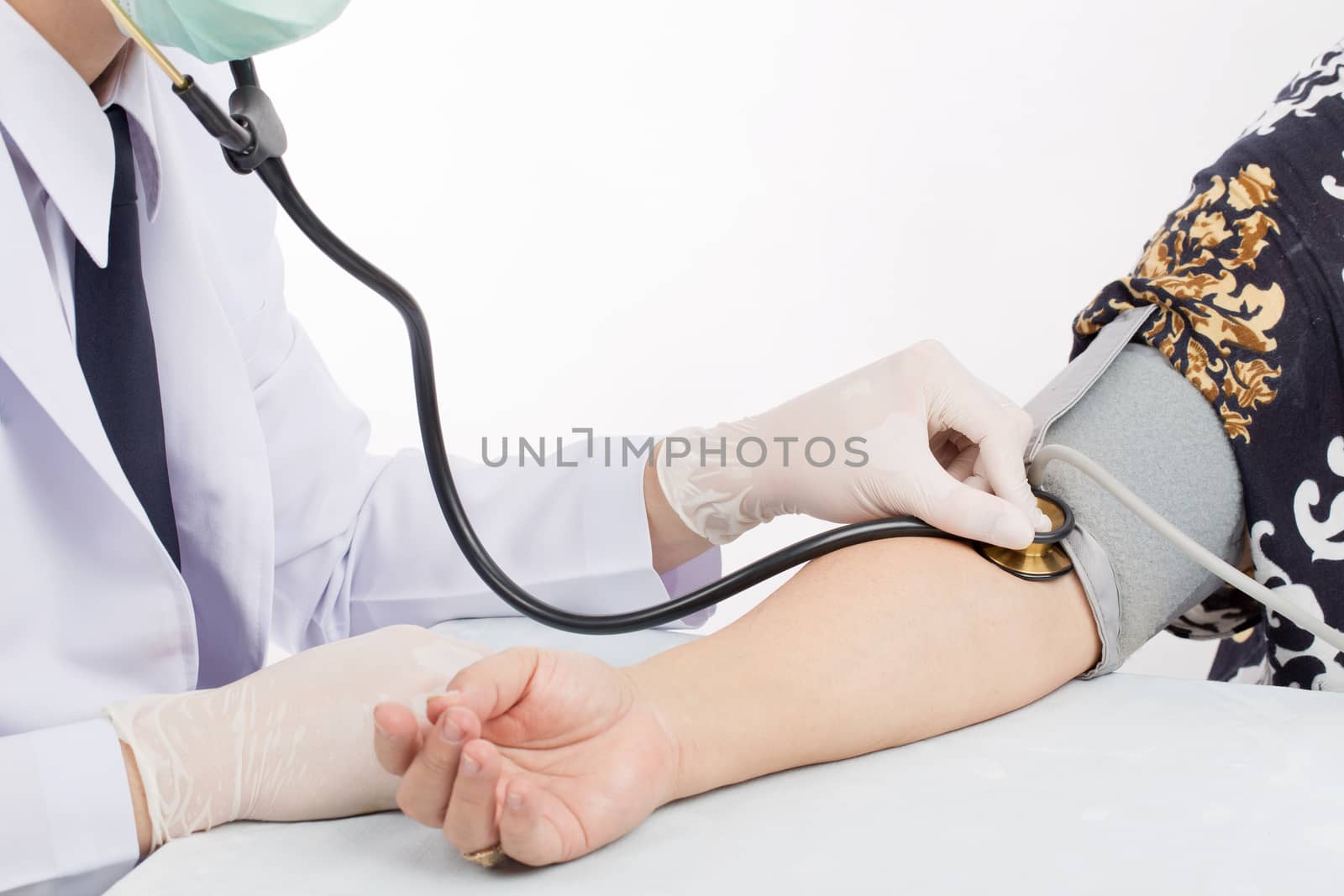 Doctor checking pulse of patient with stethoscope  on table isolated white background. 