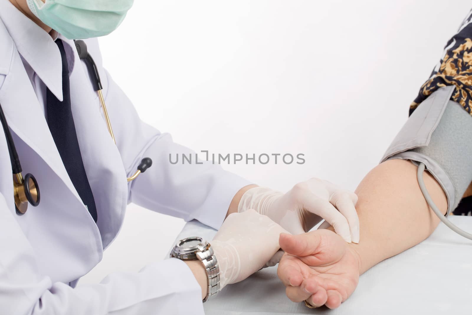 Doctor checking pulse of patient with stethoscope  on table isolated white background. 