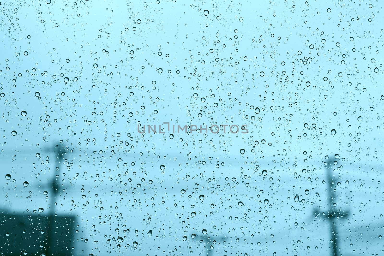Windshield rain drop car window on blue daylight.