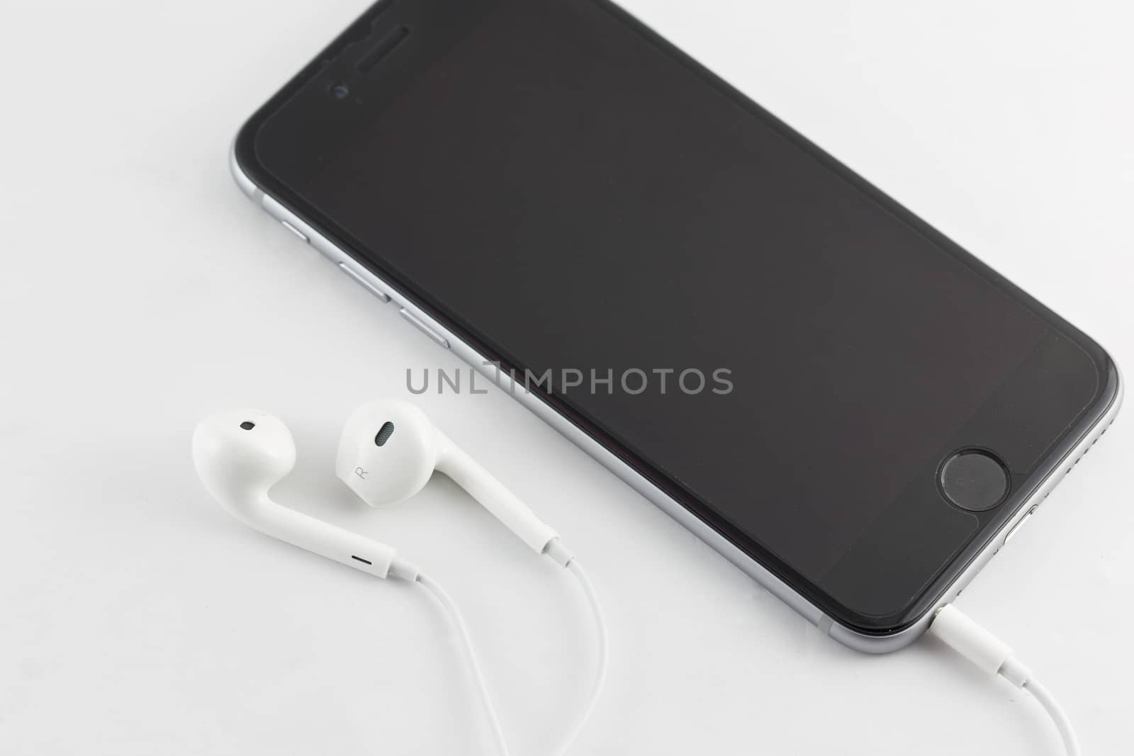 Nakhonratchasima, THAILAND - April 1, 2015 : White Earphone and Smartphone equipment set on white background : iPhone