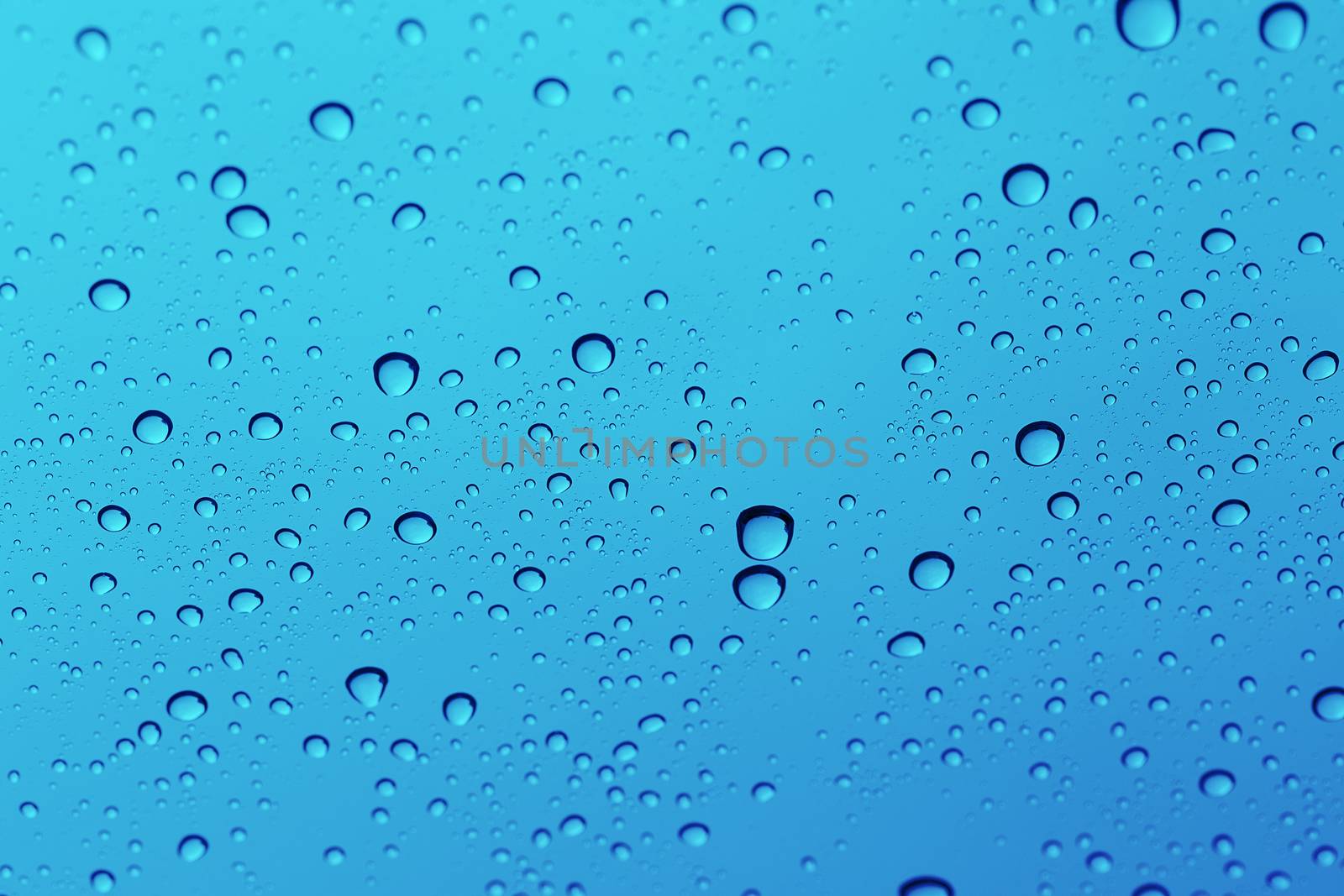 Water drop on glass mirror background. by jayzynism