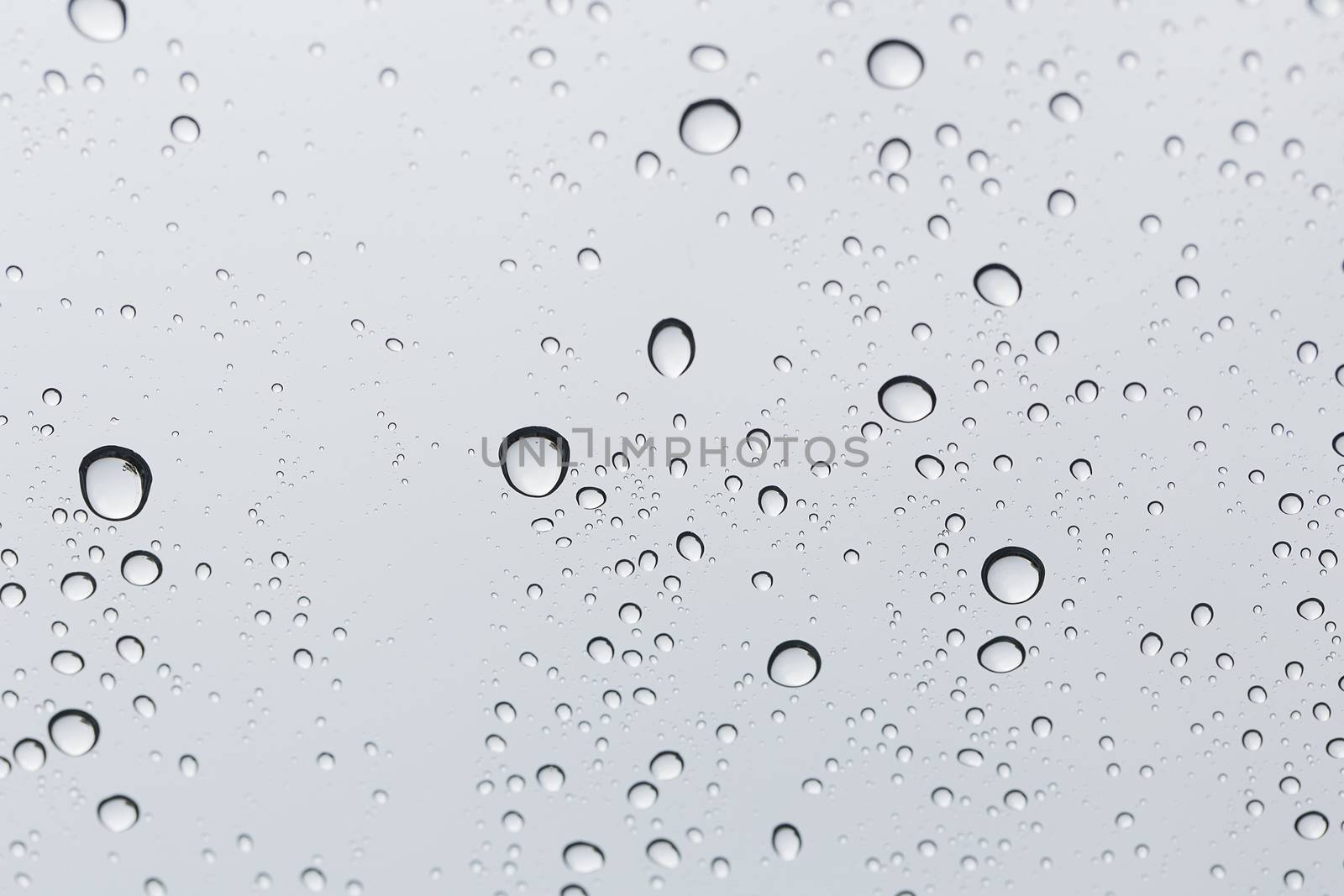 Water drop on glass mirror background. by jayzynism