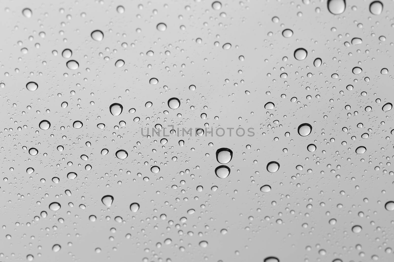 Water drop on glass mirror background. by jayzynism