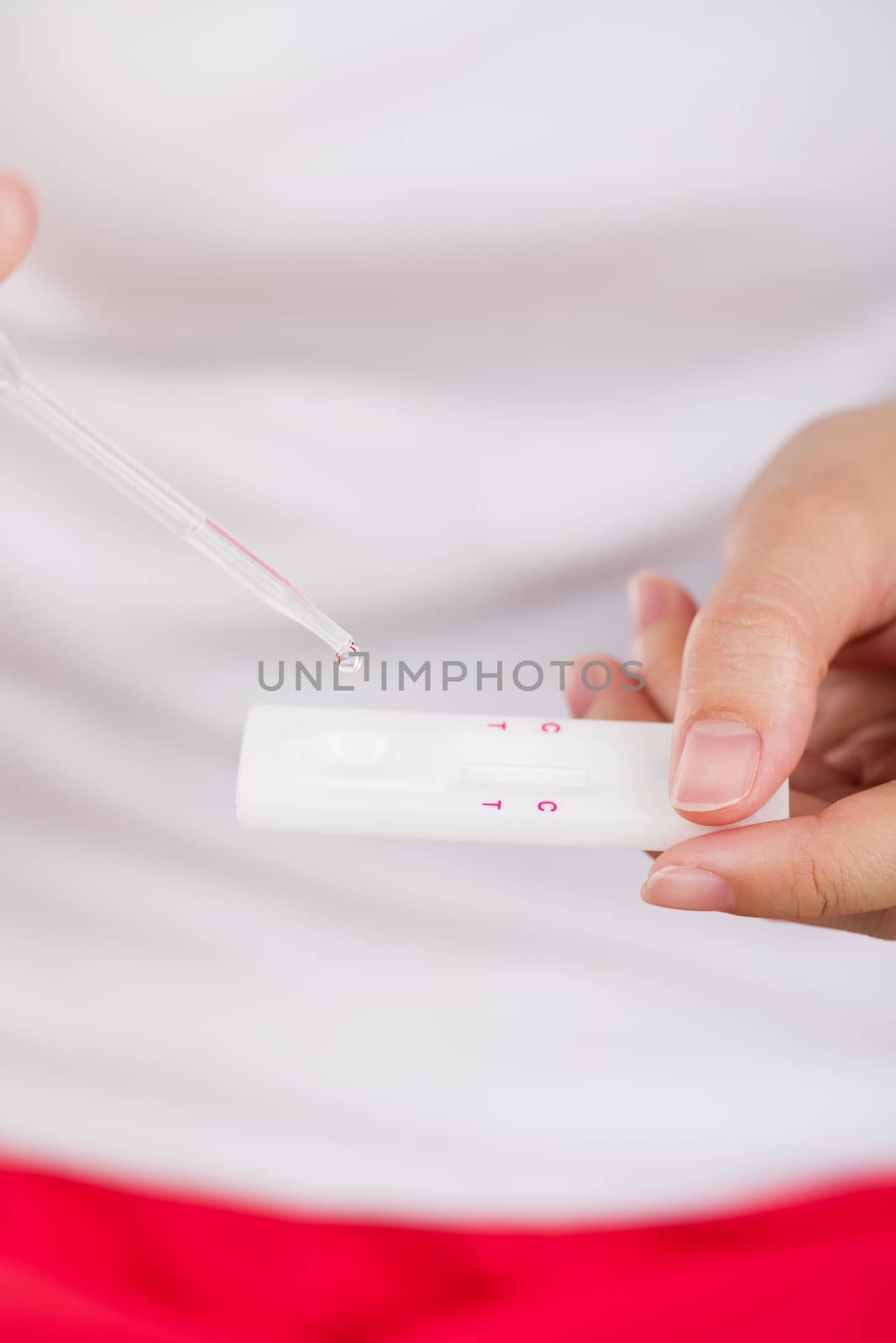 Young women checking pregnancy test. by jayzynism