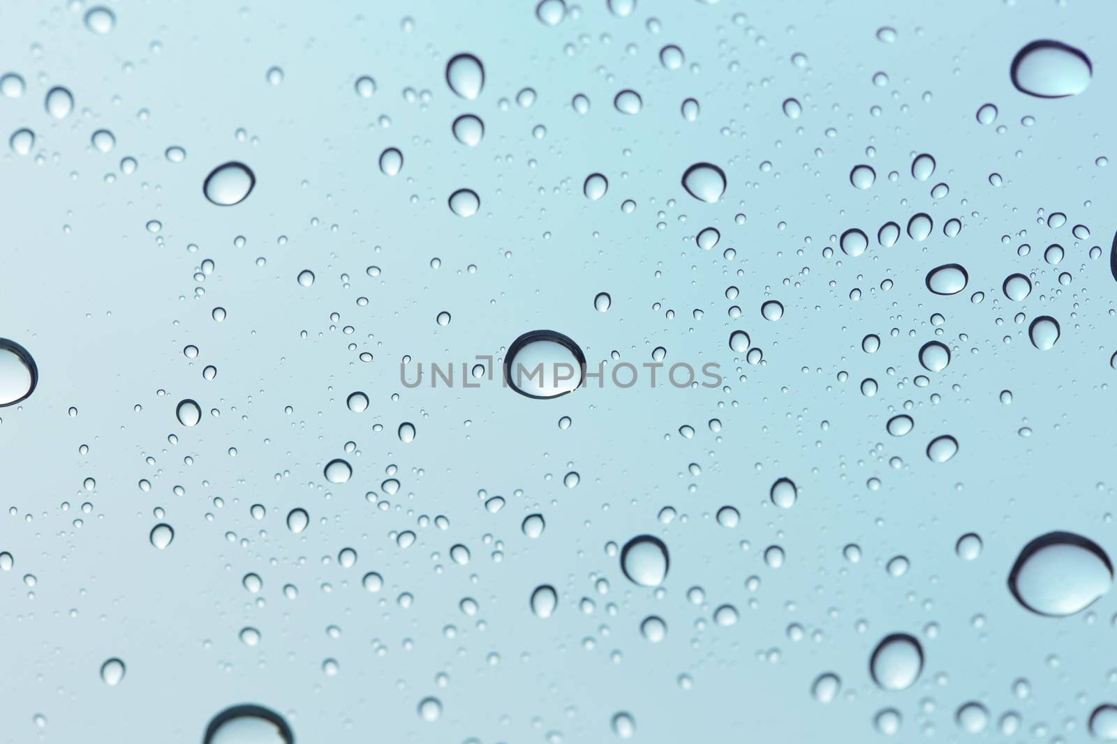 Water drop on sky glass mirror background.