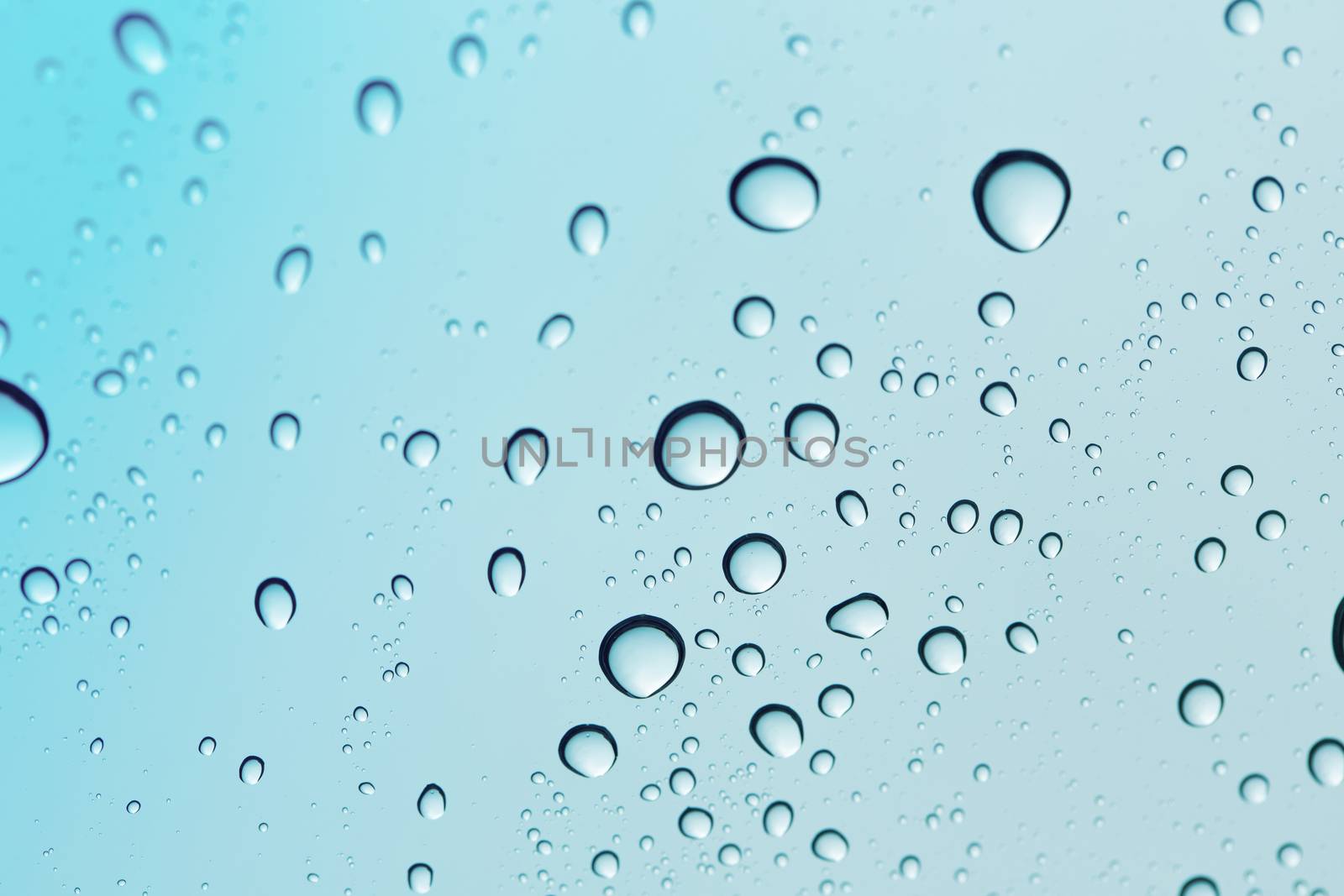 Water drop blue sky on glass mirror background.