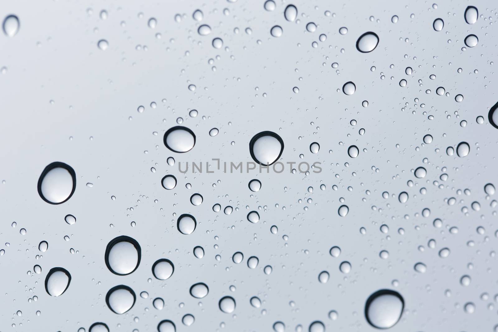 Water drop on glass mirror background.