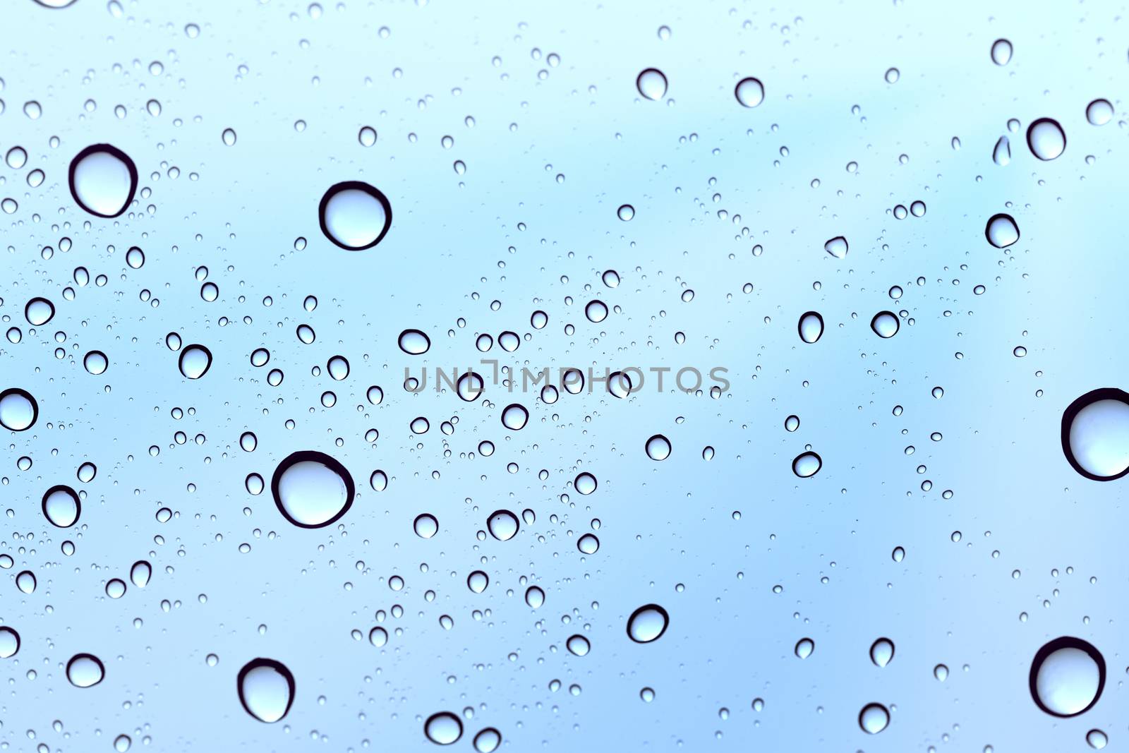 Water drop sky flare on glass mirror background. by jayzynism