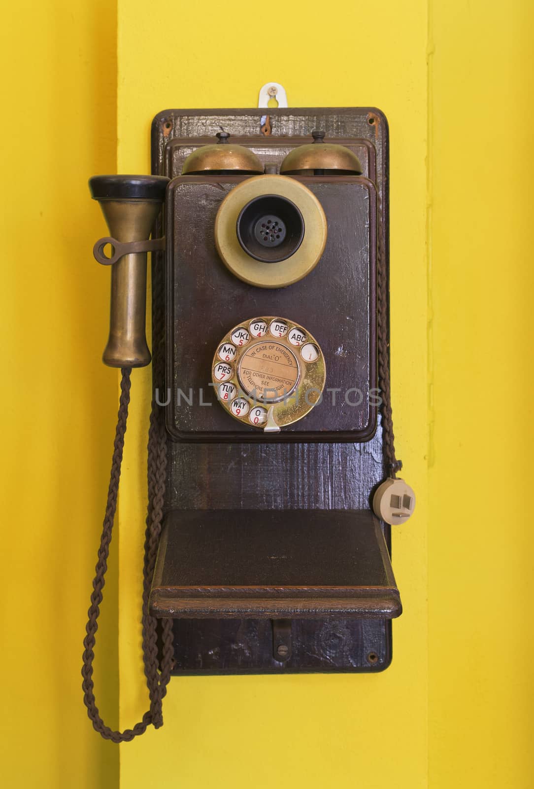 Antique vintage telephone yellow grunge background.