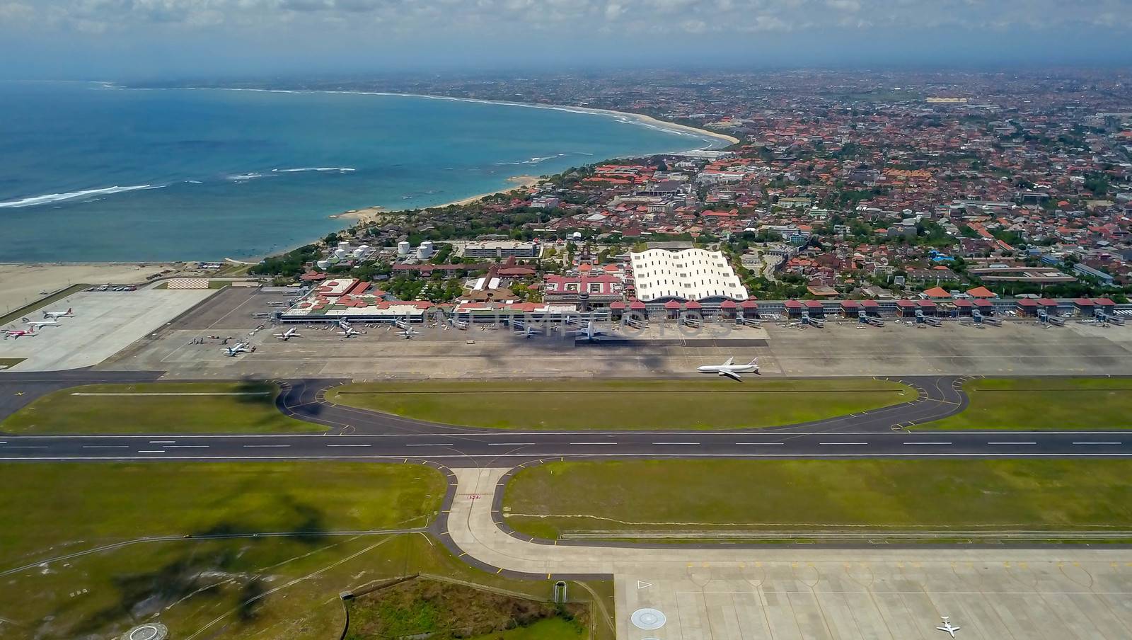 Commercial aircraft taxi on the runway at Denpasar Airport in Bali, Indonesia. Drone view of a big jet preparing to take off. Jet airplane turns to runway. Passenger jet prepares for departure.