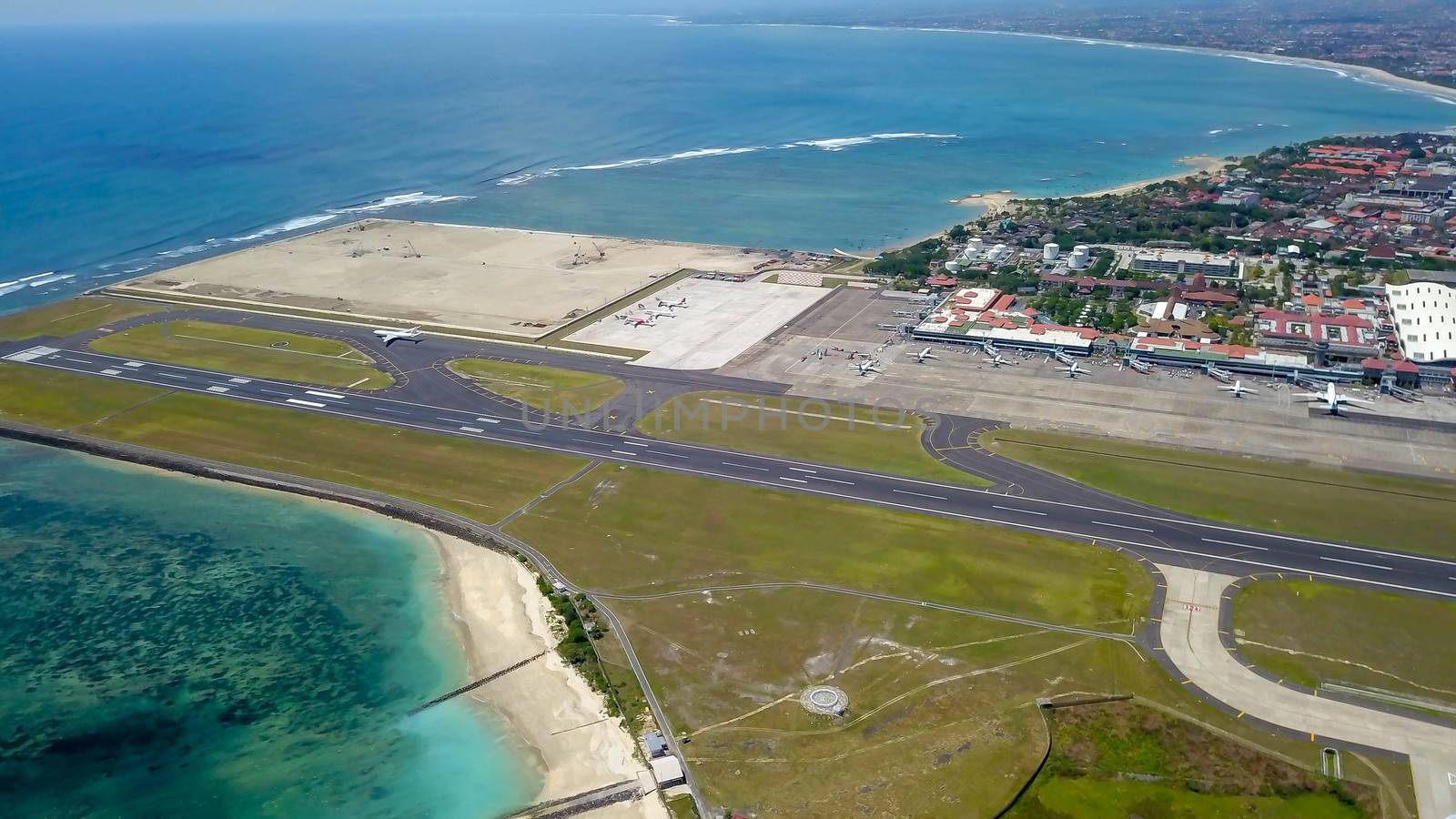 Commercial aircraft taxi on the runway at Denpasar Airport in Bali, Indonesia. Drone view of a big jet preparing to take off. Jet airplane turns to runway. Passenger jet prepares for departure by Sanatana2008