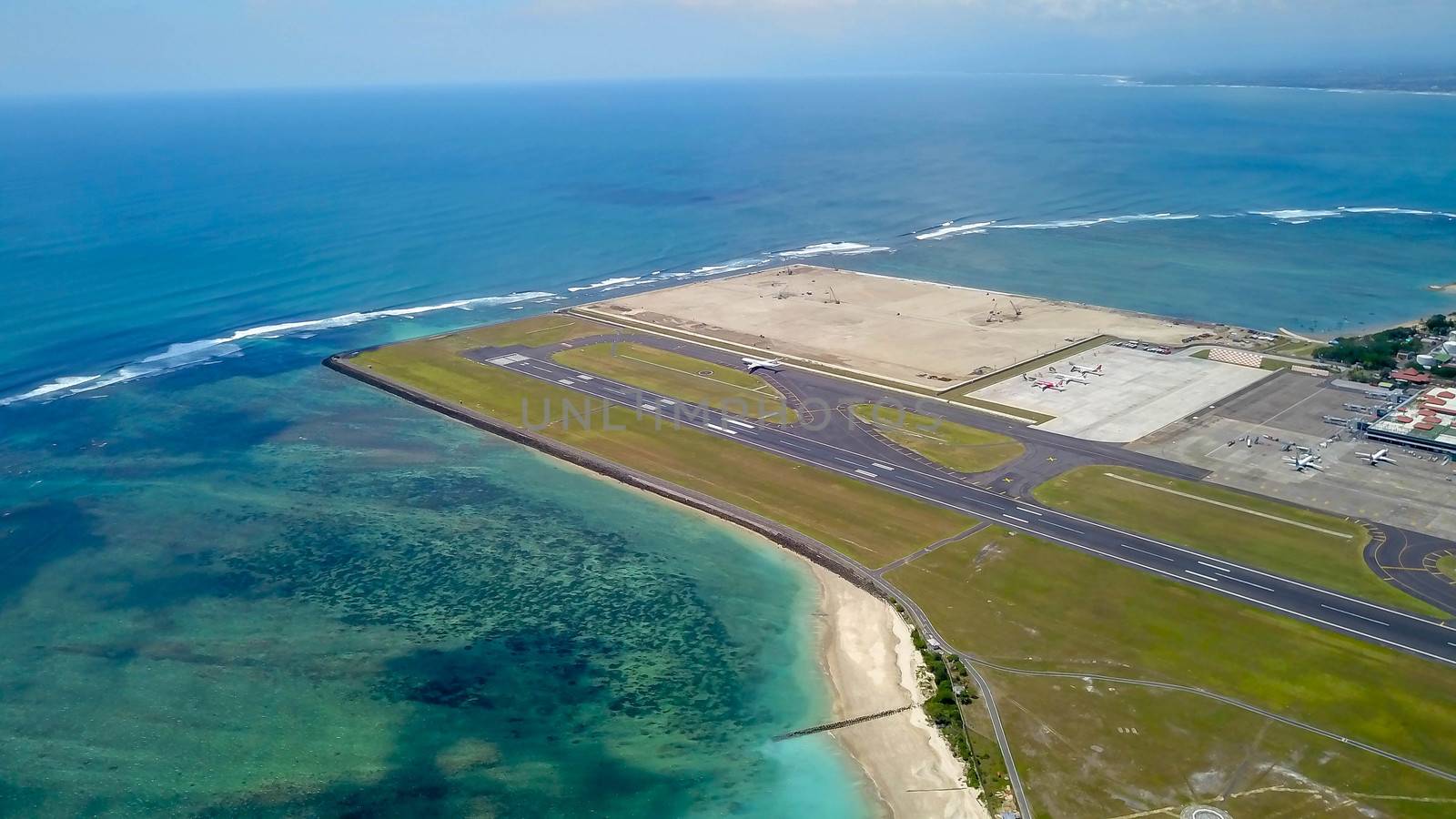 Commercial aircraft taxi on the runway at Denpasar Airport in Bali, Indonesia. Drone view of a big jet preparing to take off. Jet airplane turns to runway. Passenger jet prepares for departure.